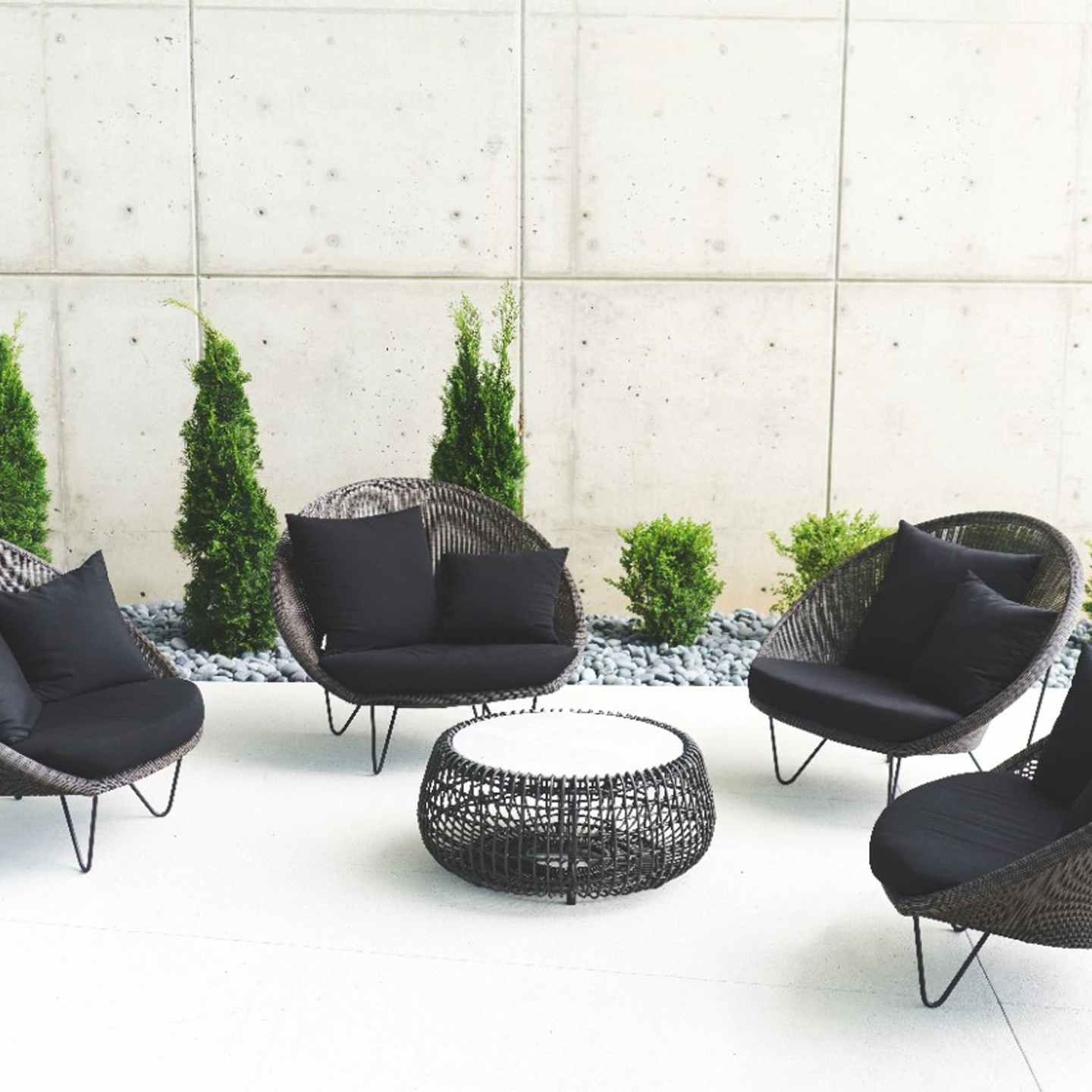 Haworth Gigi II lounge chairs in black cane material with black cushions in an outdoor space