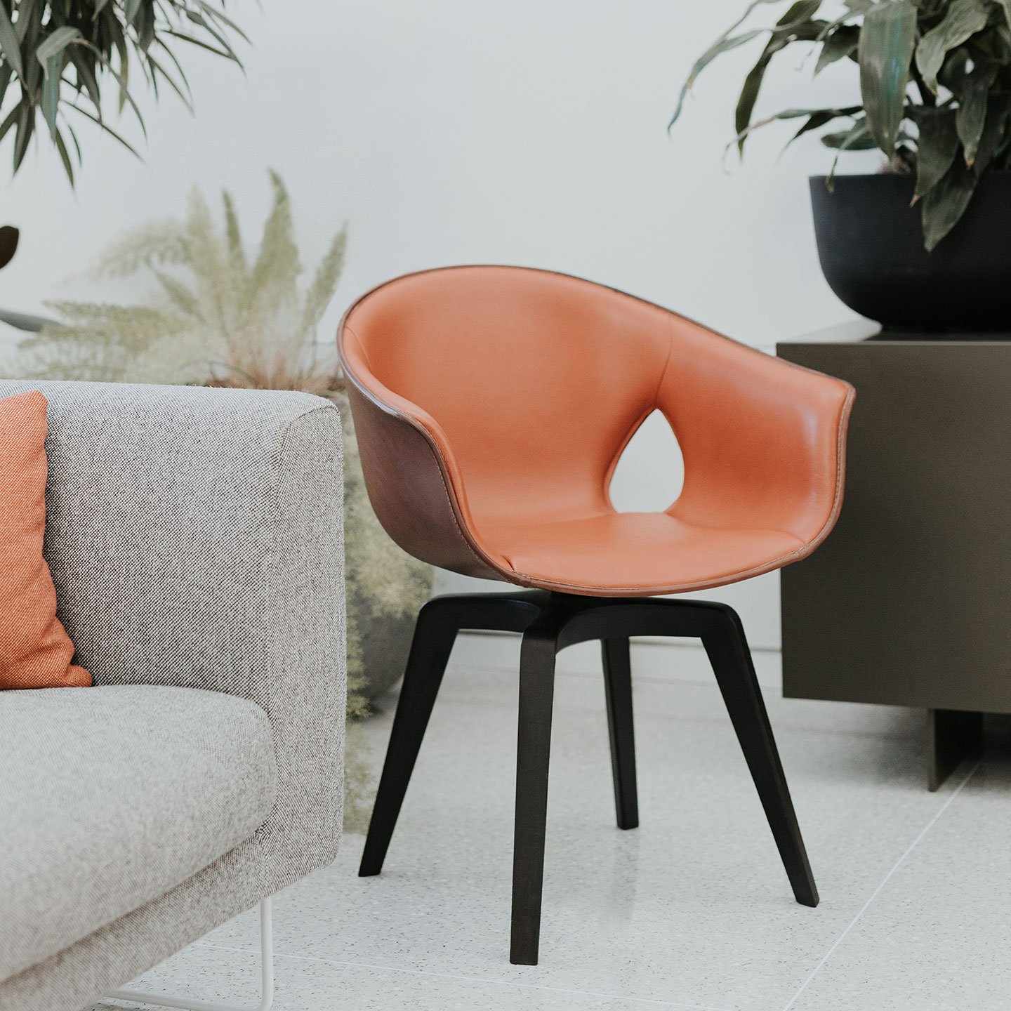 Haworth Ginger chair in orange upholstery and brown exterior in a lounge space