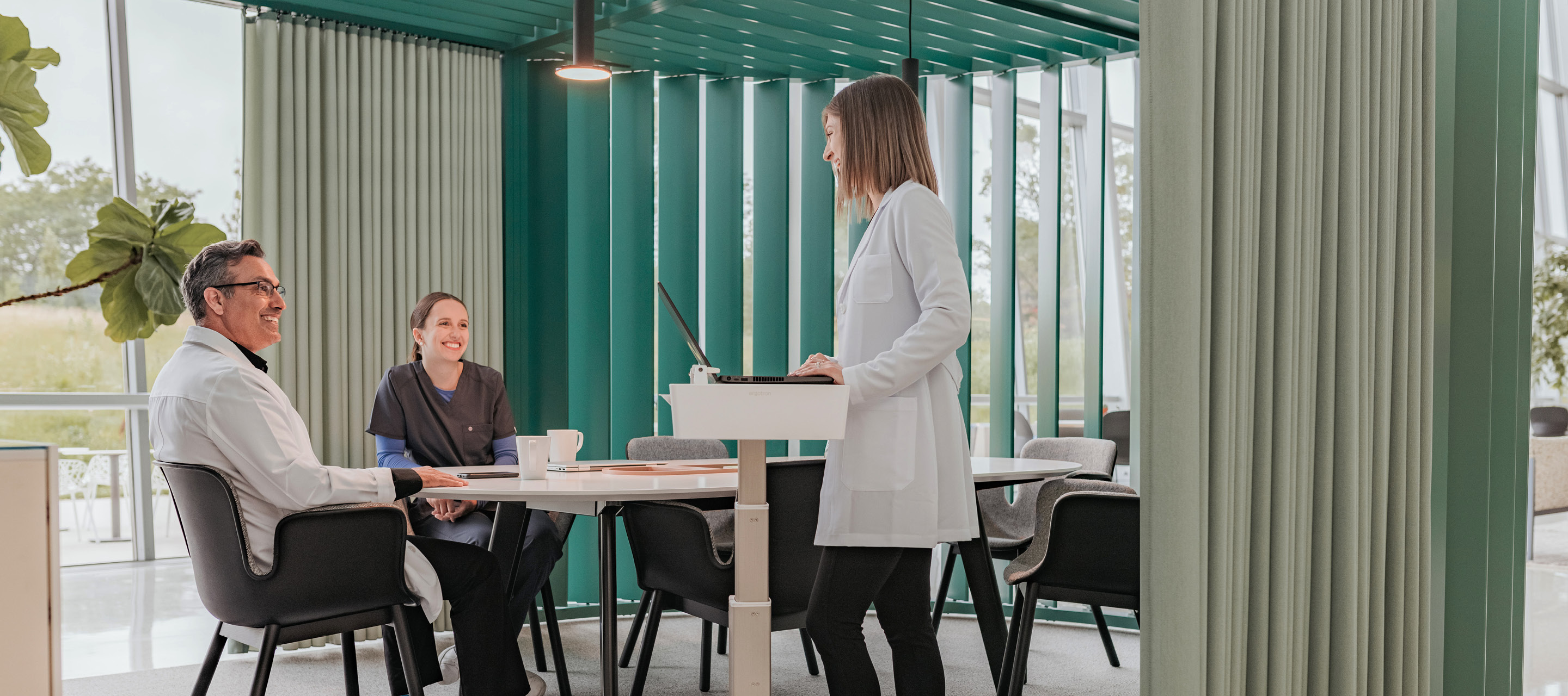 Healthcare professionals and caregivers using Haworth chairs, tables and desks in a healthcare pavilion