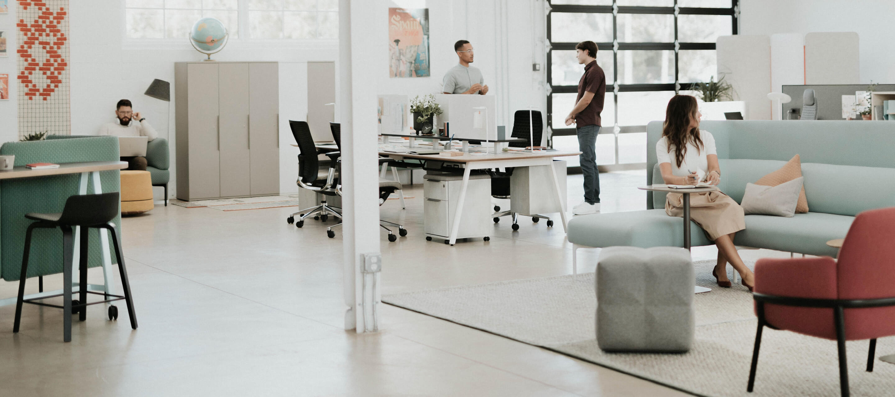 individual workspaces surrounded by a lounge area with employees interacting/