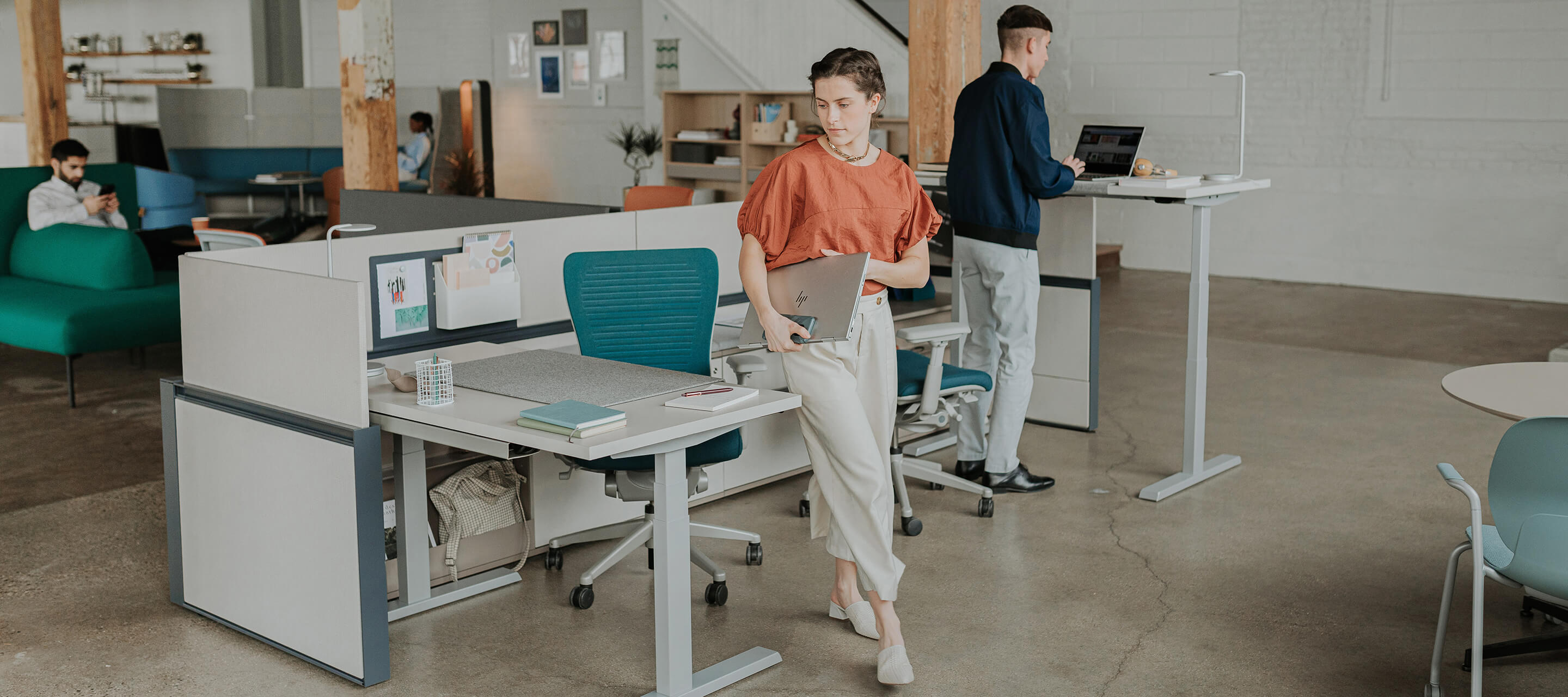 open floor plan with individual workspaces with planes height adjustable desks and blue Zody chairs./