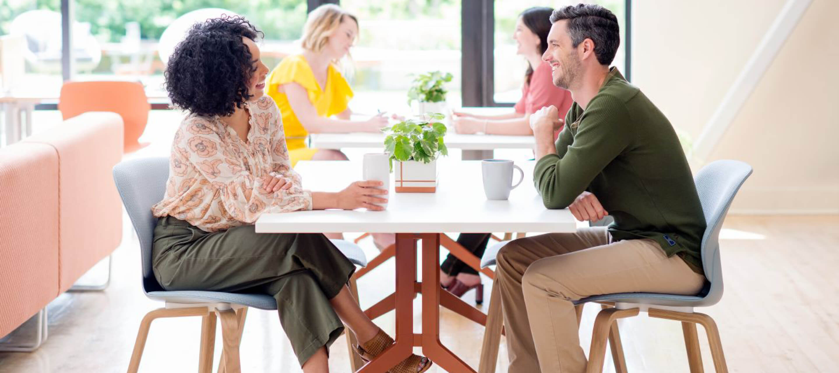 coworkers meeting over coffee on the planes collaborative table and sitting on Maari