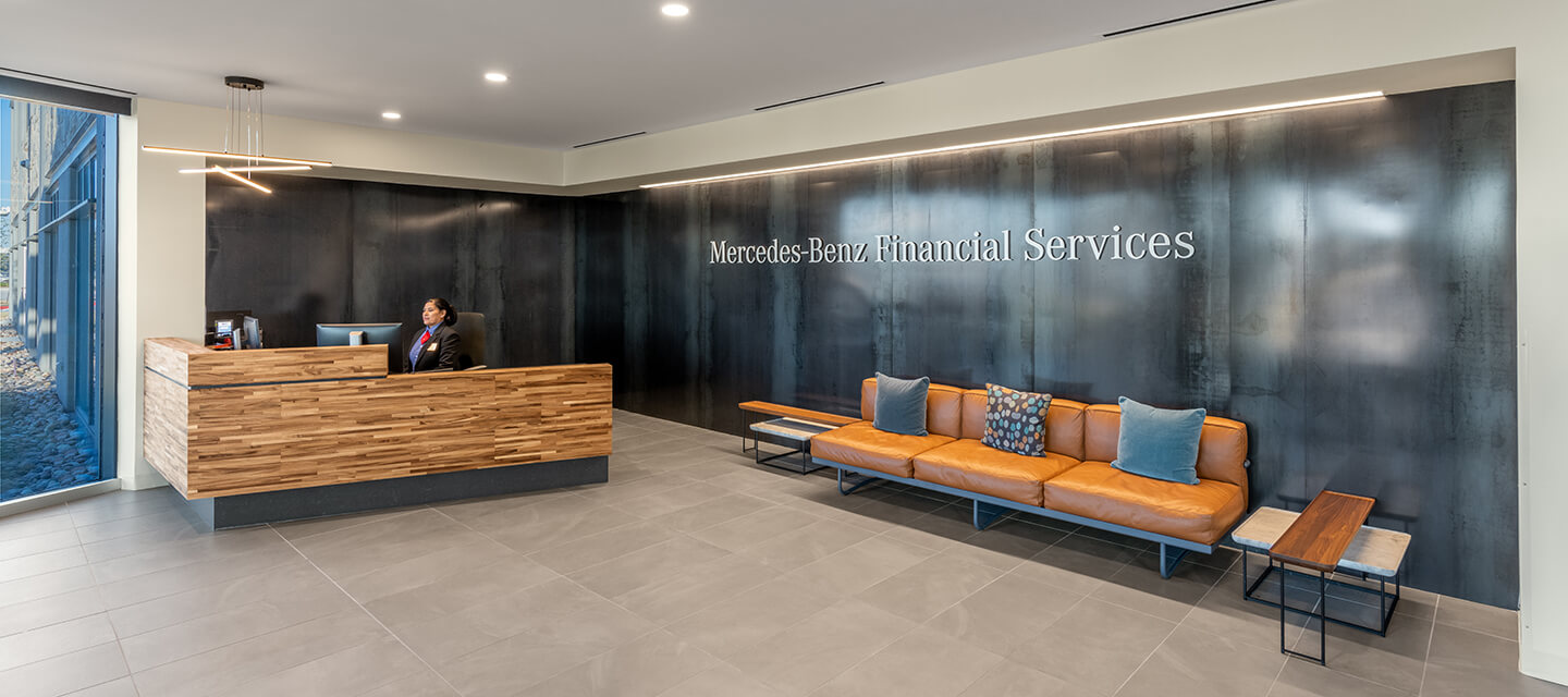 The inviting reception area is sophisticated and sleek. The textural backdrop offers a modern contrast to the soft leather seating and stackable Torei tables by Cassina.  