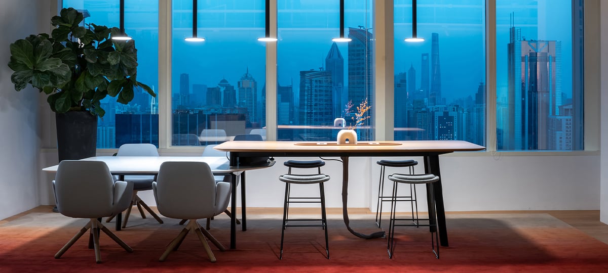 Combinación de mesas altas y bajas Immerse con ambiente natural, un espacio ideal para ponerse al día con el equipo o para reuniones ocasionales con clientes.