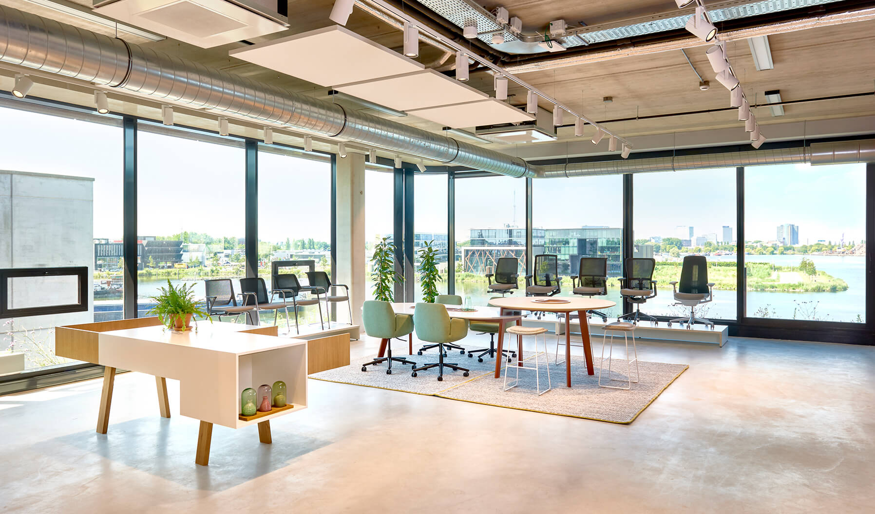 La zona de cocreación sirve de inspiración a los visitantes con sus vistas panorámicas del puerto y diversas soluciones de la cartera de productos de sillería de Haworth. La mesa Immerse ofrece un espacio de reunión formal.