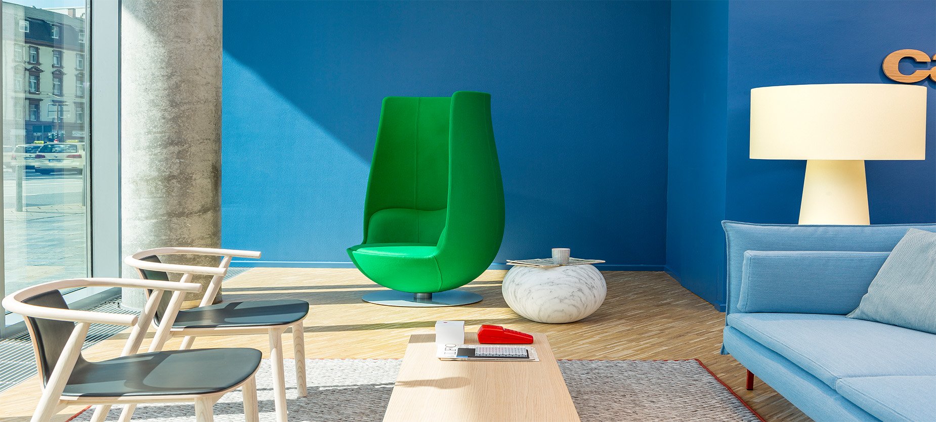 Cappellini系列家具迎接着访客到来：两把Bac椅子、Tulip绿色扶手椅、Gong边桌，以及Big Shadow落地灯。