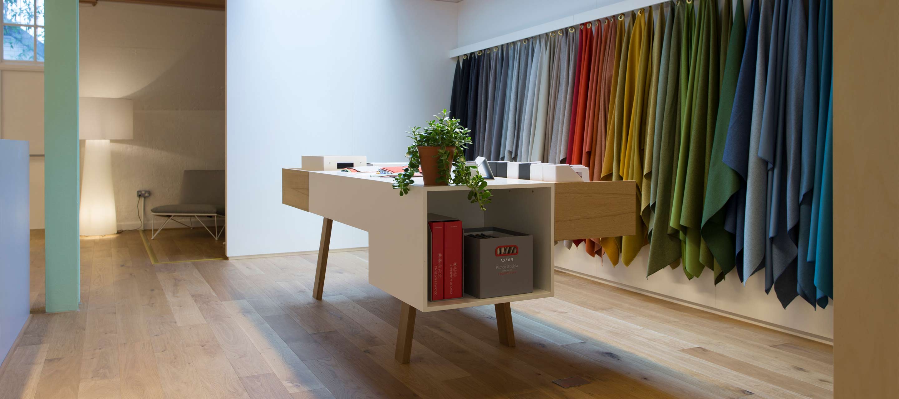 Las personas que visitan el showroom de Londres pueden sentir el tacto de nuestros tejidos y observar los acabados en este estand con muestras de colores y materiales.