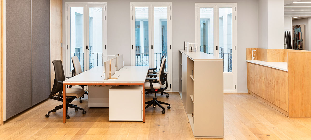 Storage cupboards are used to delineate the space between workstations and a small kitchen area.