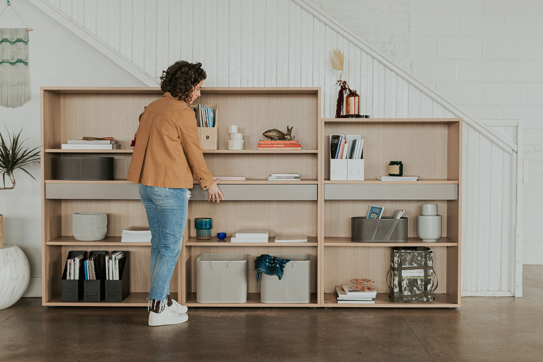 Wood Be_Hold bookshelves in varying heights in open office space. 