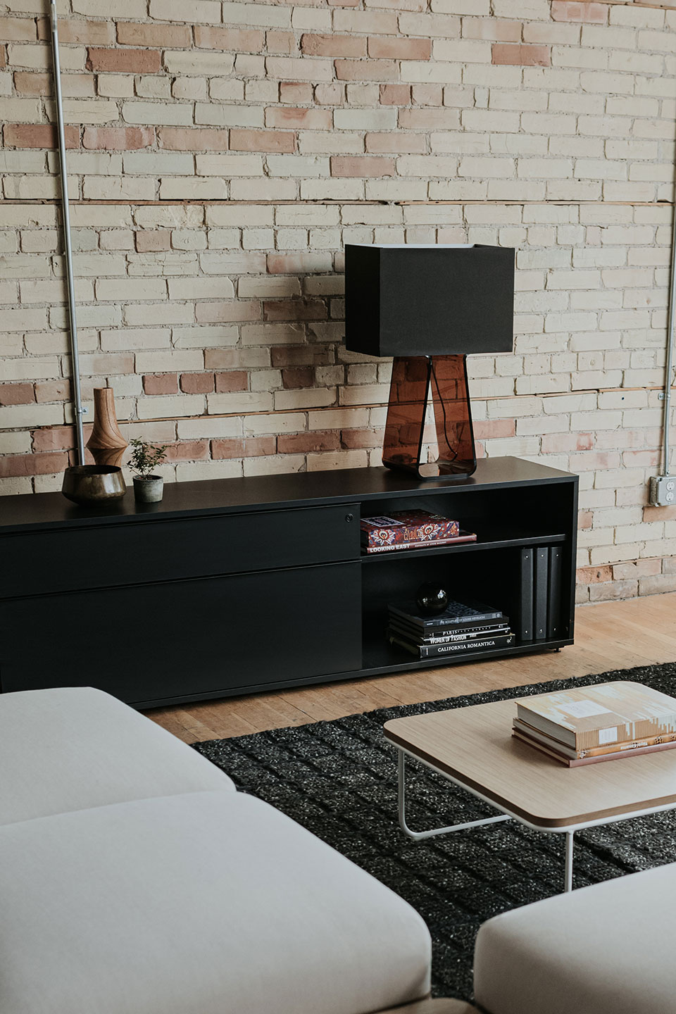 Black Be_Hold storage credenza in private living room with Tube Top lamp.