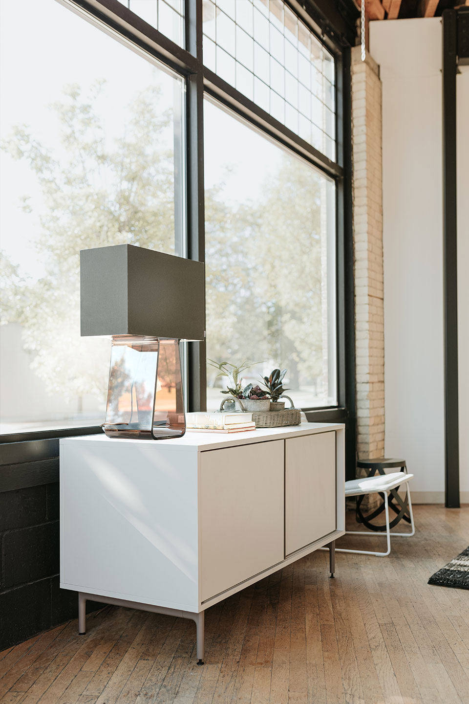 White Be_Hold storage credenza with sliding doors in private living room with Tube Top lamp. 