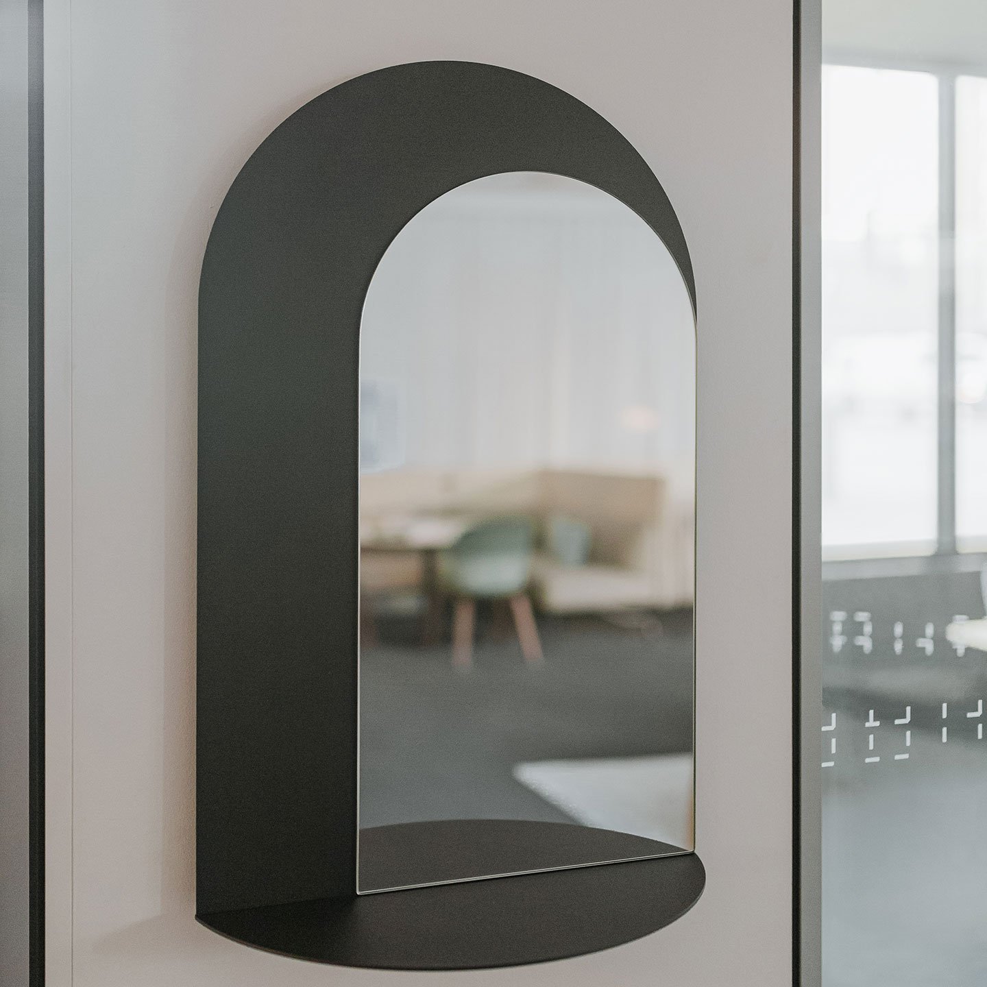Haworth BuzziMirage Accessories in black on a white wall next to a glass wall 
