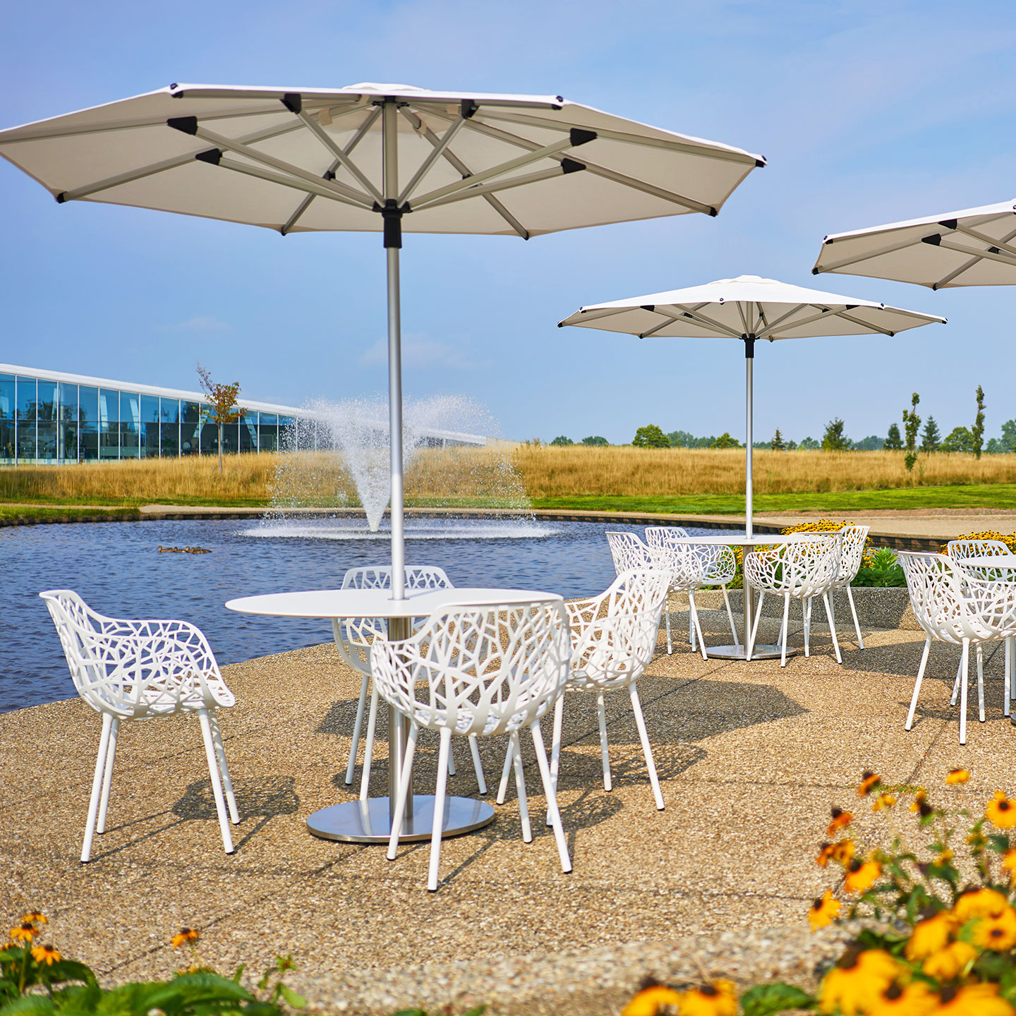 Haworth Janus Titan Umbrella Accessories on outdoor seating area covering tables next to fountain