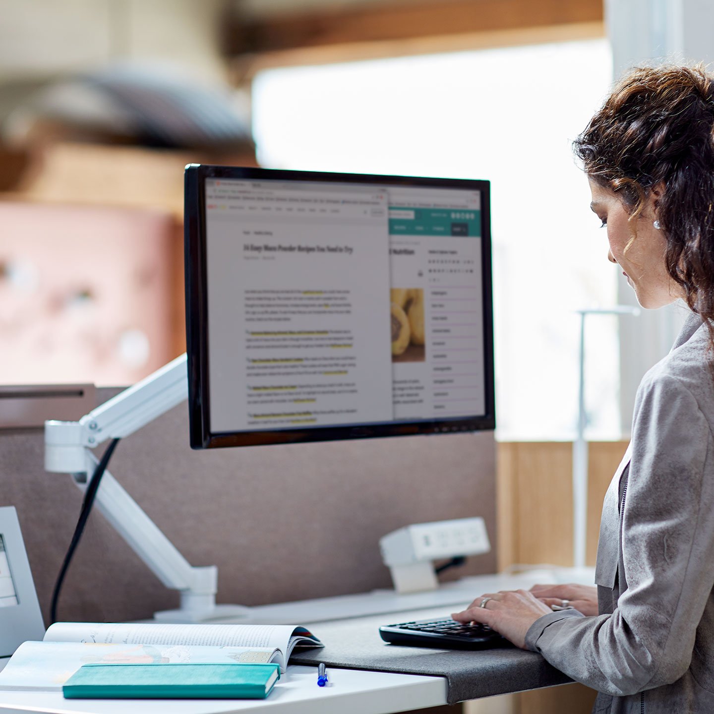 Haworth Monitor Arm Accessories at a desk with employee working in office