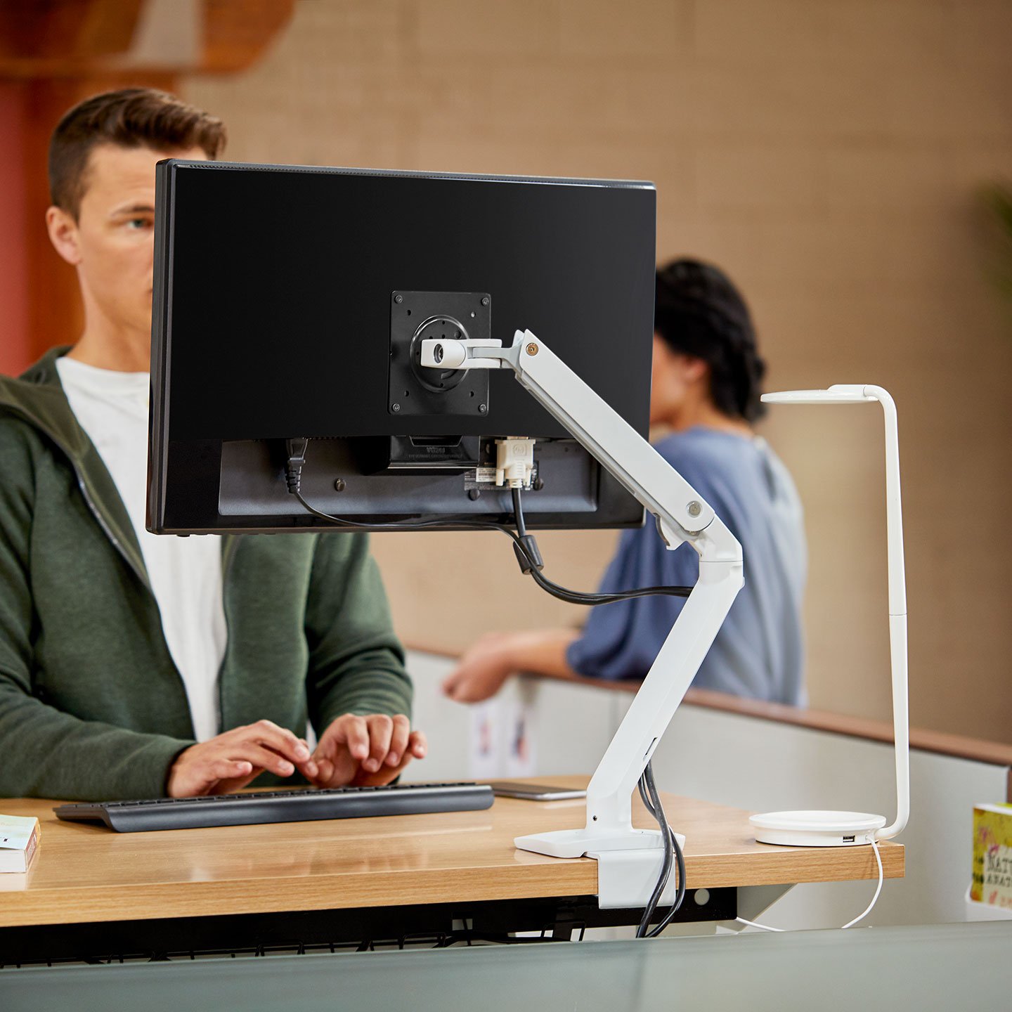 Haworth Monitor Arm Accessories at a desk in an office space with an employee working on it