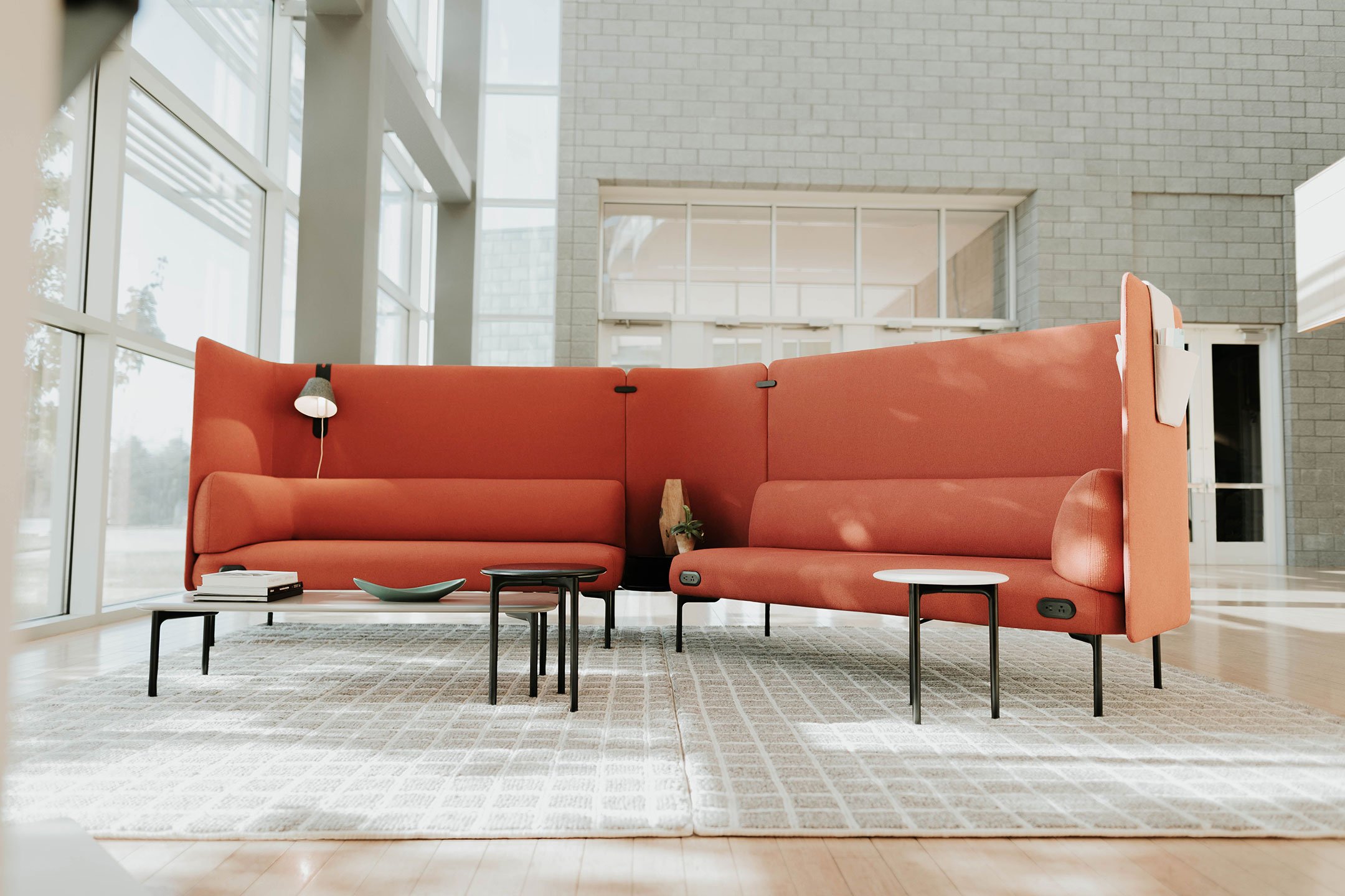 Haworth Cabana Lounge in orange color with tall booth around it in open office space with small wood tables