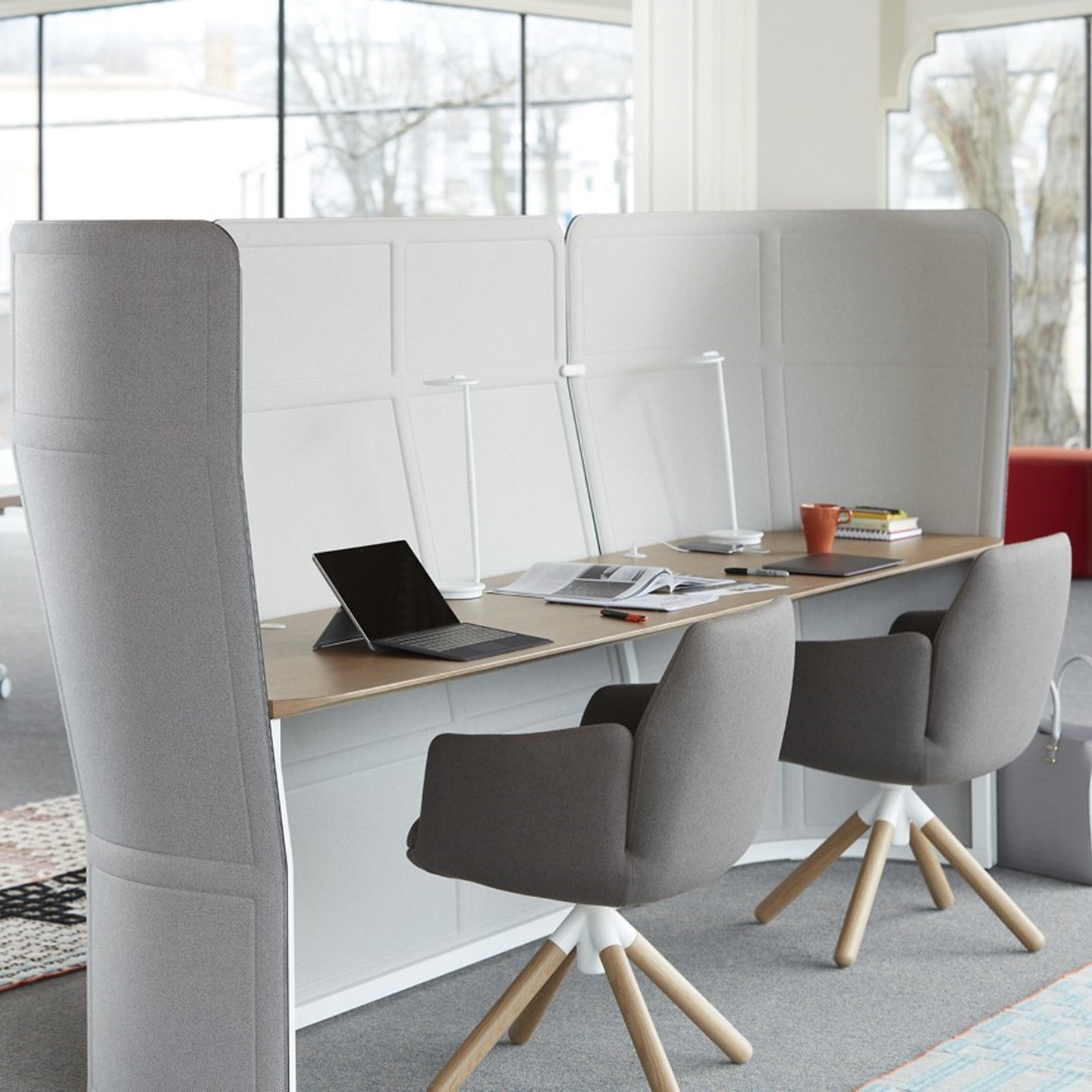 Haworth Openest Double Desk Booth with grey chairs at desk and lights with office supplies in open office space