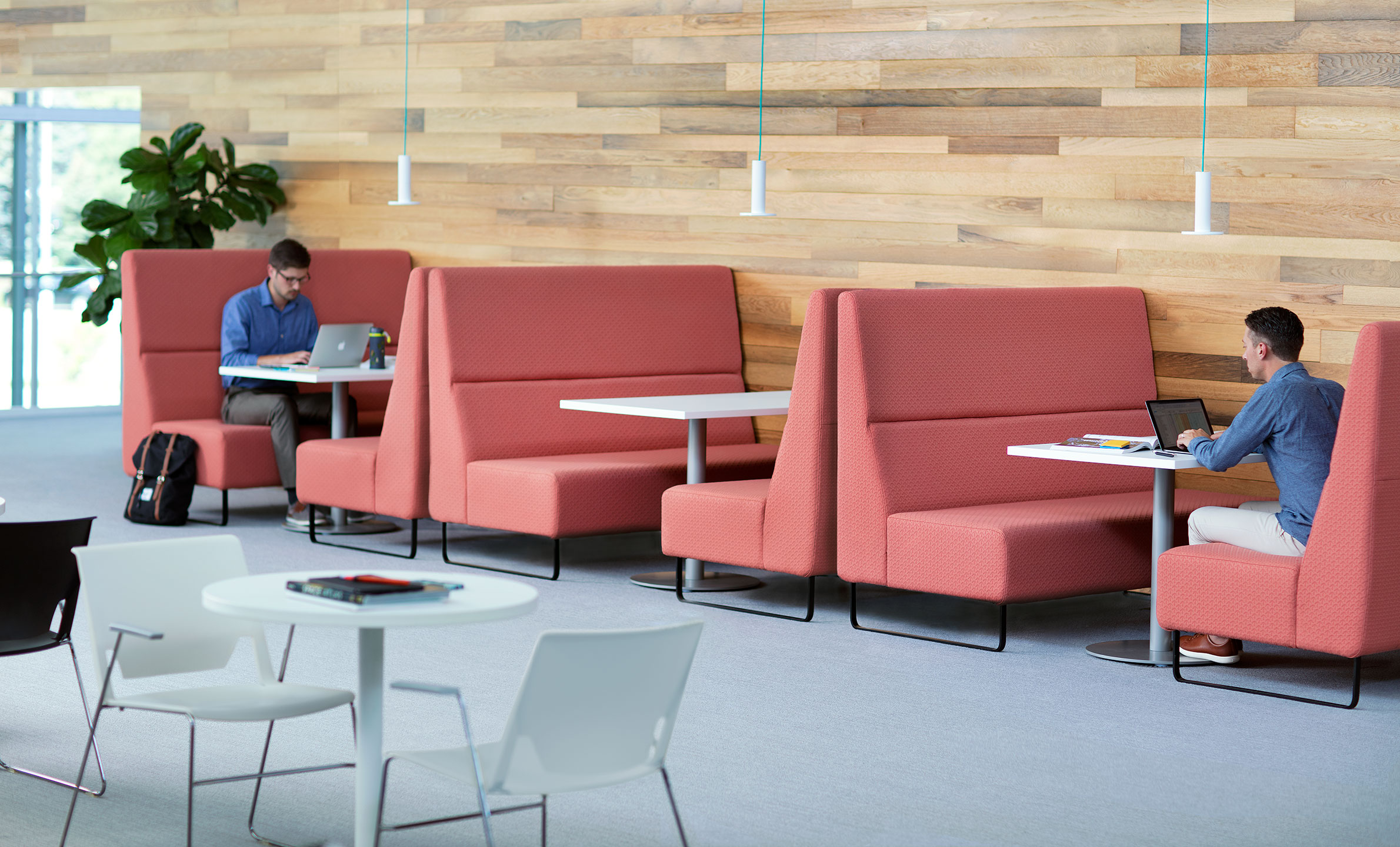 Haworth Riverbend and Pebble Booth in salmon color with employees working at the private tables in office open lounge area