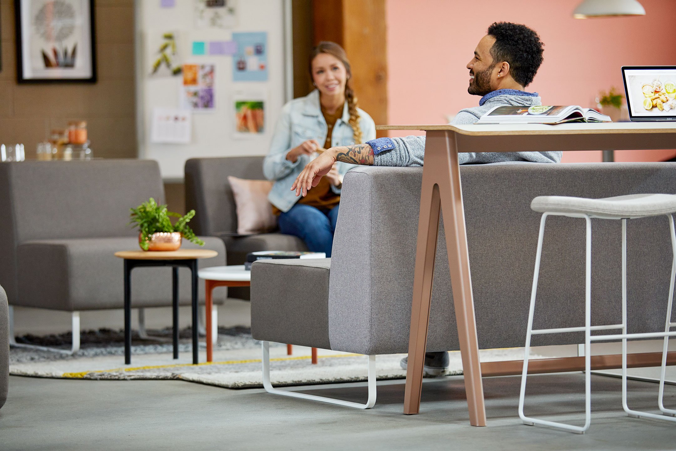 Haworth Riverbend and Pebble Booth in grey color with employees sitting down talking to each other in open office area