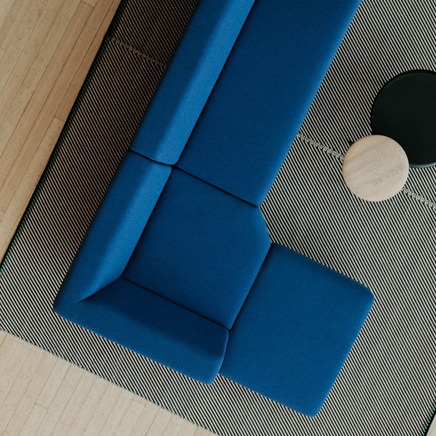 Haworth Riverbend and Pebble Booth in blue color with stripped rug and veneer center tables