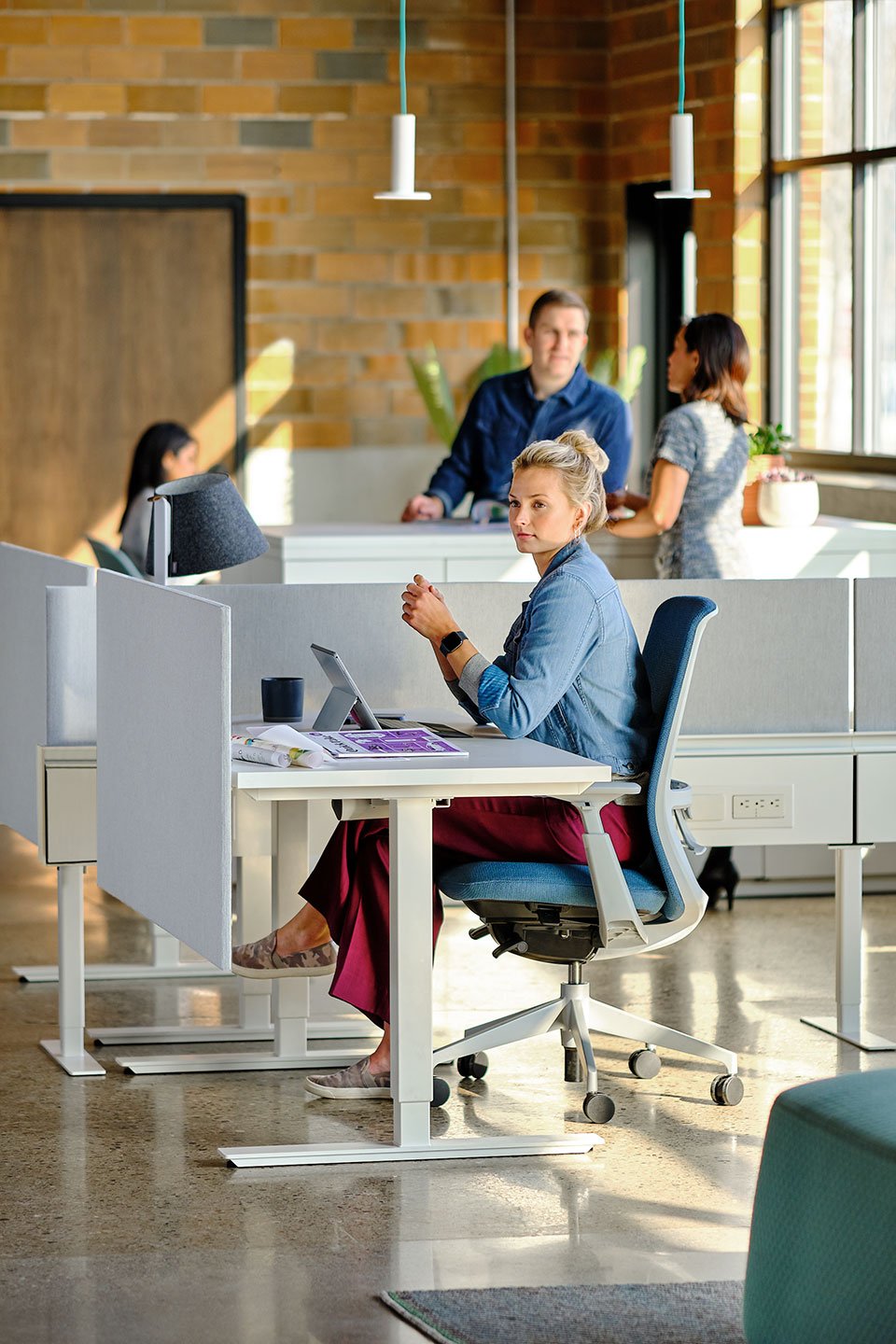 Haworth Compose Beam Divider in office space with employee working at desk and employees talking in the back