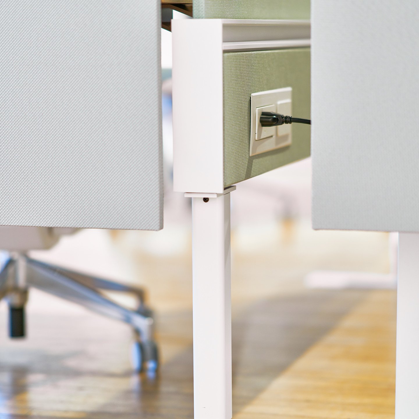 Haworth Compose Beam Workspace divider in office space with desk power strip outlet plugged into wall socket