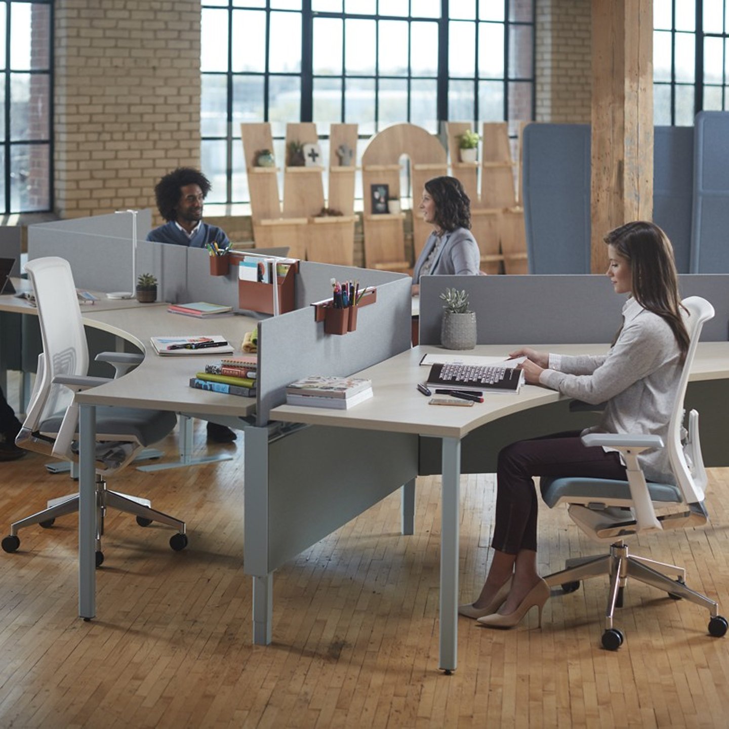 Haworth Compose Connections Workspace divider in grey in an office space with employees working at desks with wood floor and brick walls