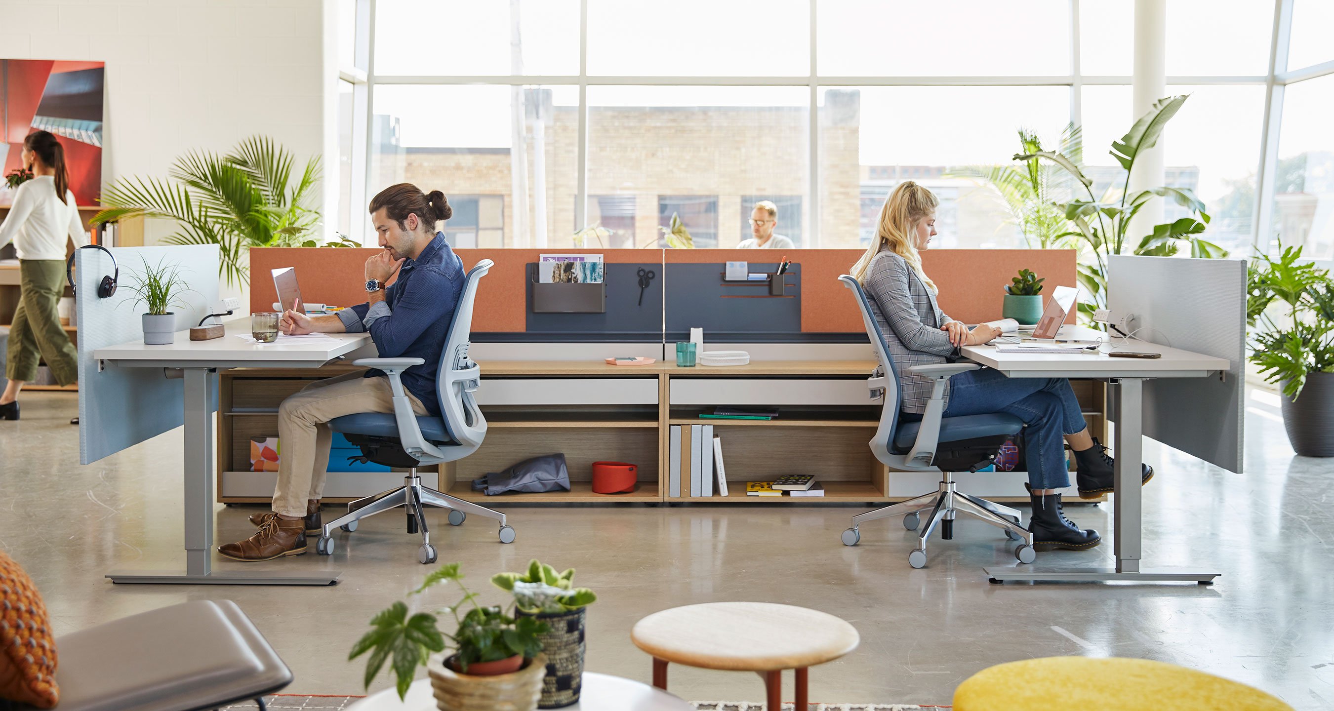 Haworth Compose Workspace in office space with desks facing opposite directions and employee working at them 