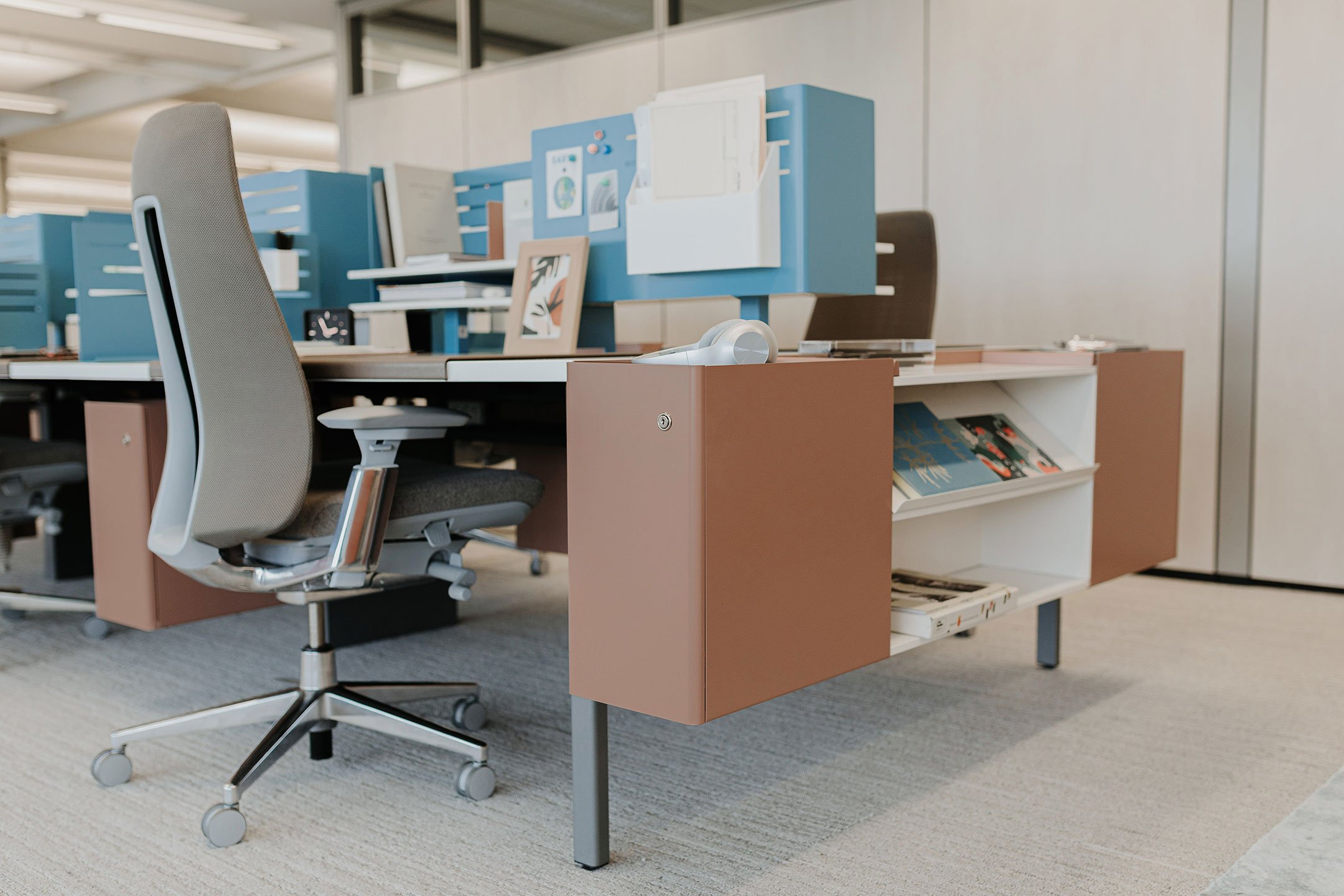 Haworth Intuity Workspace divider in blue color seperating desks in office space with fern chairs at them 