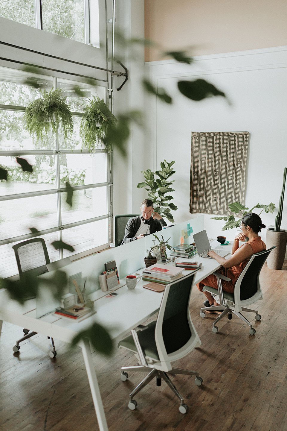 Haworth Intuity Workspace divider that are translucent in plant office space with employees working at desk next to glass overhead door