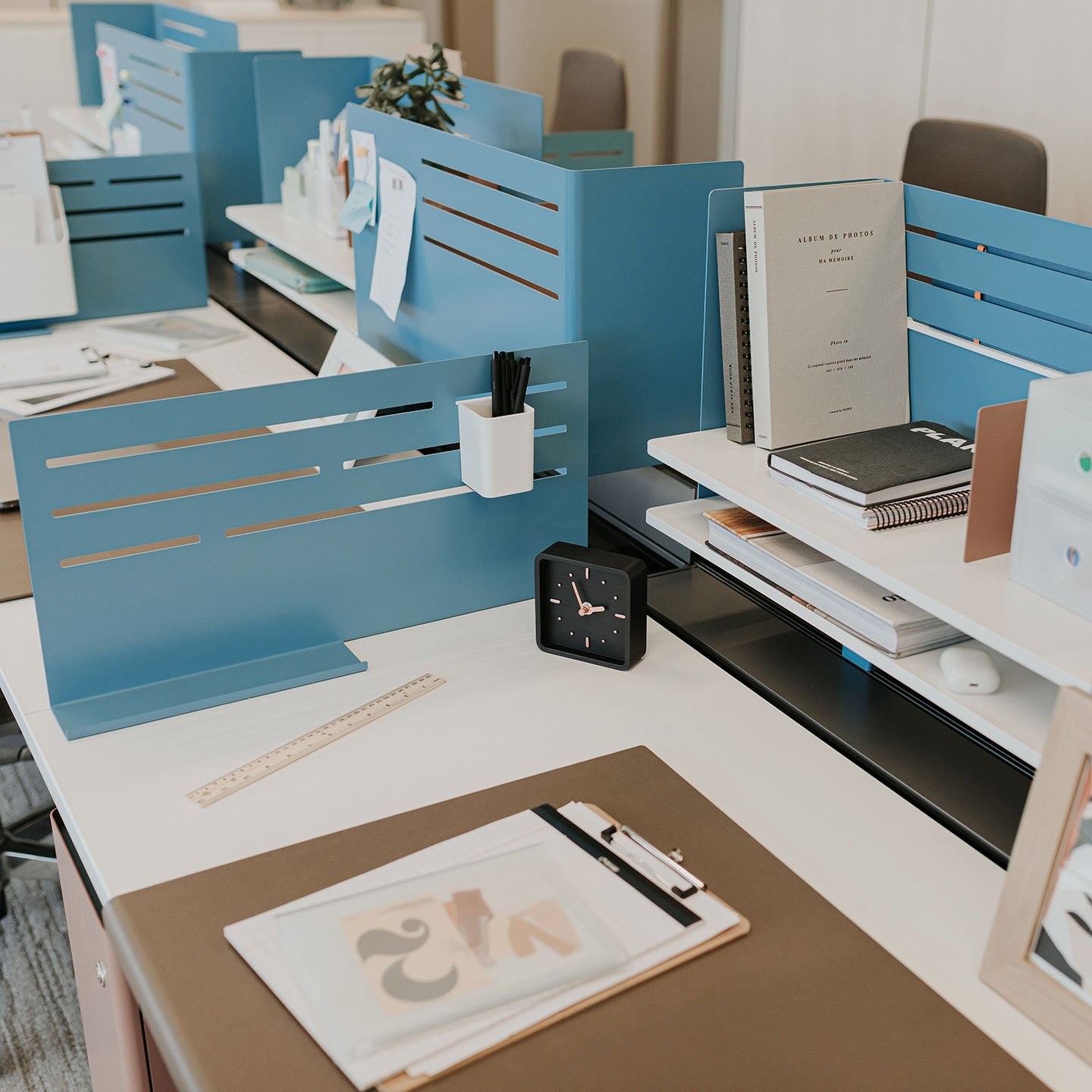 Haworth Intuity Workspace divider in blue color separating desks with papers on them