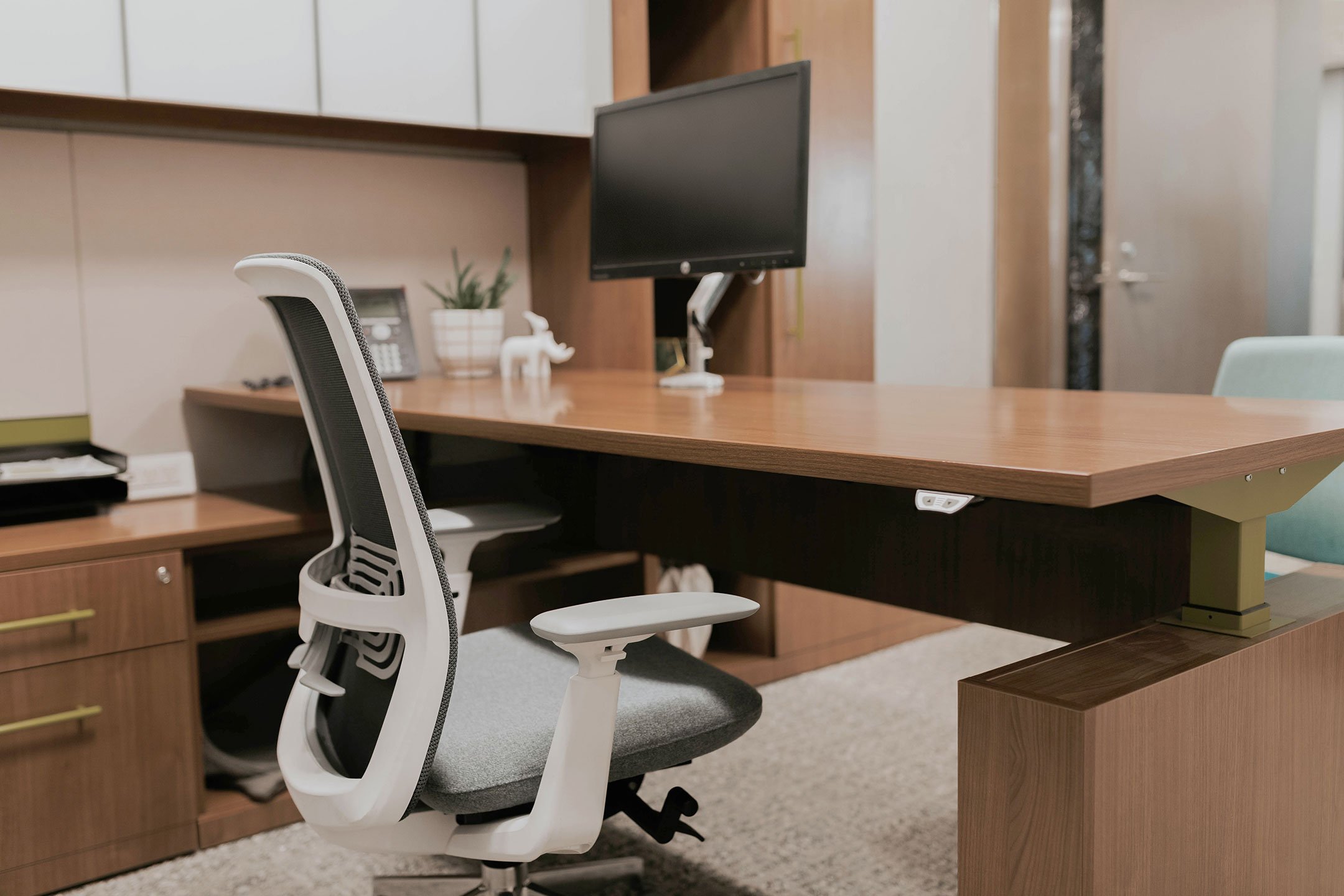 Haworth Masters Series Workspace in private office space in veneer with monitor on desk and shelves and storage space with chairs on opposite sides of the desk