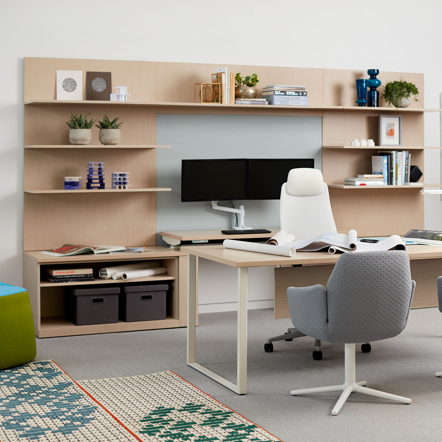 Haworth Masters Series Workspace Veneer height adjustable desk with monitor on desk in private office space with white chair and grey chairs and shelving unit