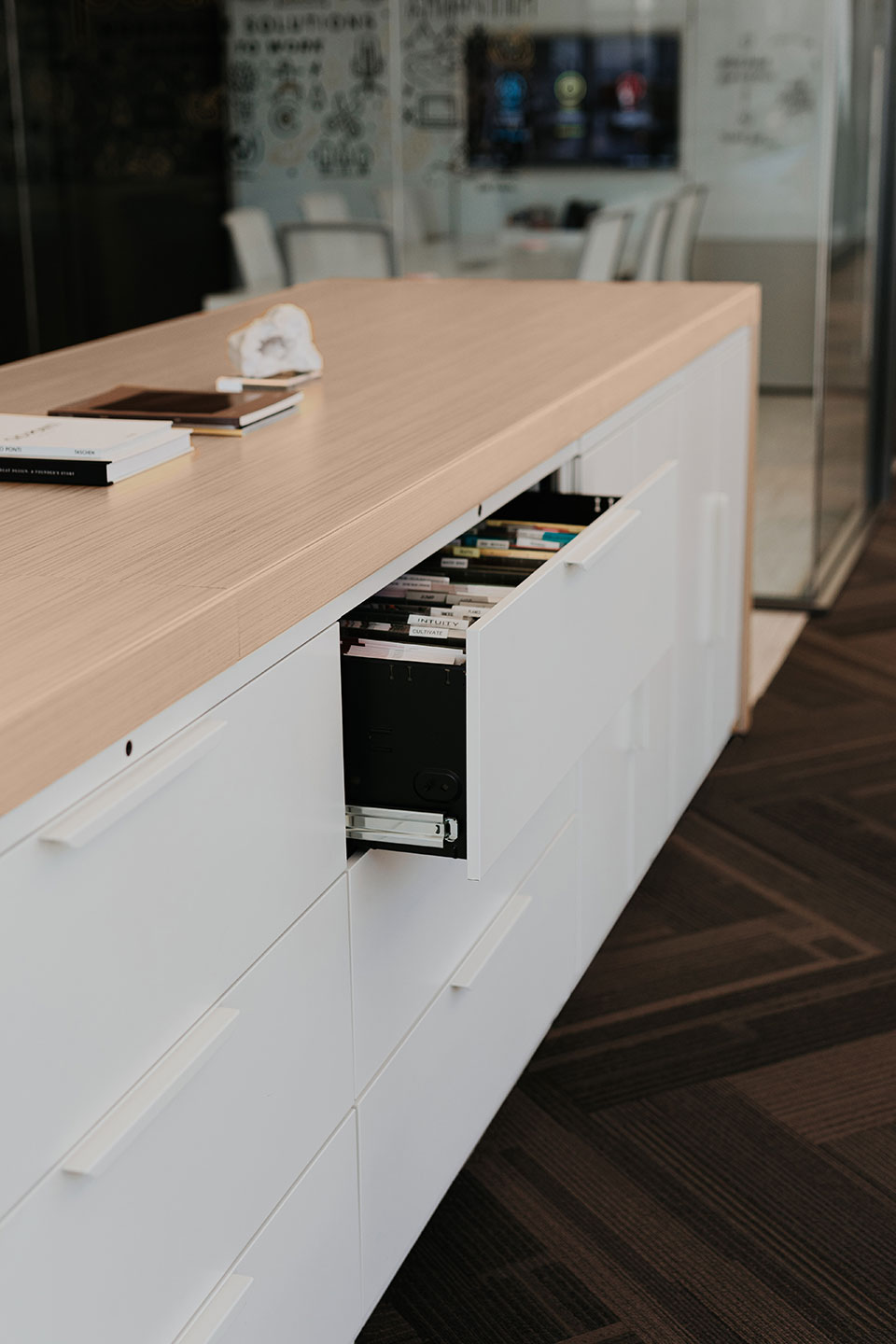 Haworth Patterns Architectural Workspace in office space with a veneer top and white drawers with a open drawer with files