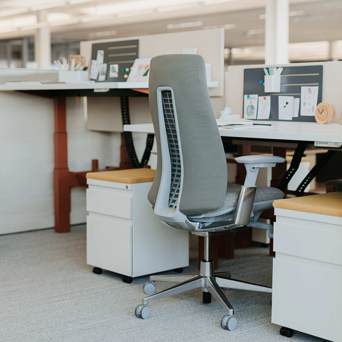 Haworth Planes LT Height Adjustable Benching Workspace veneer desks in office mock up with blue dividers between desks and one is raised