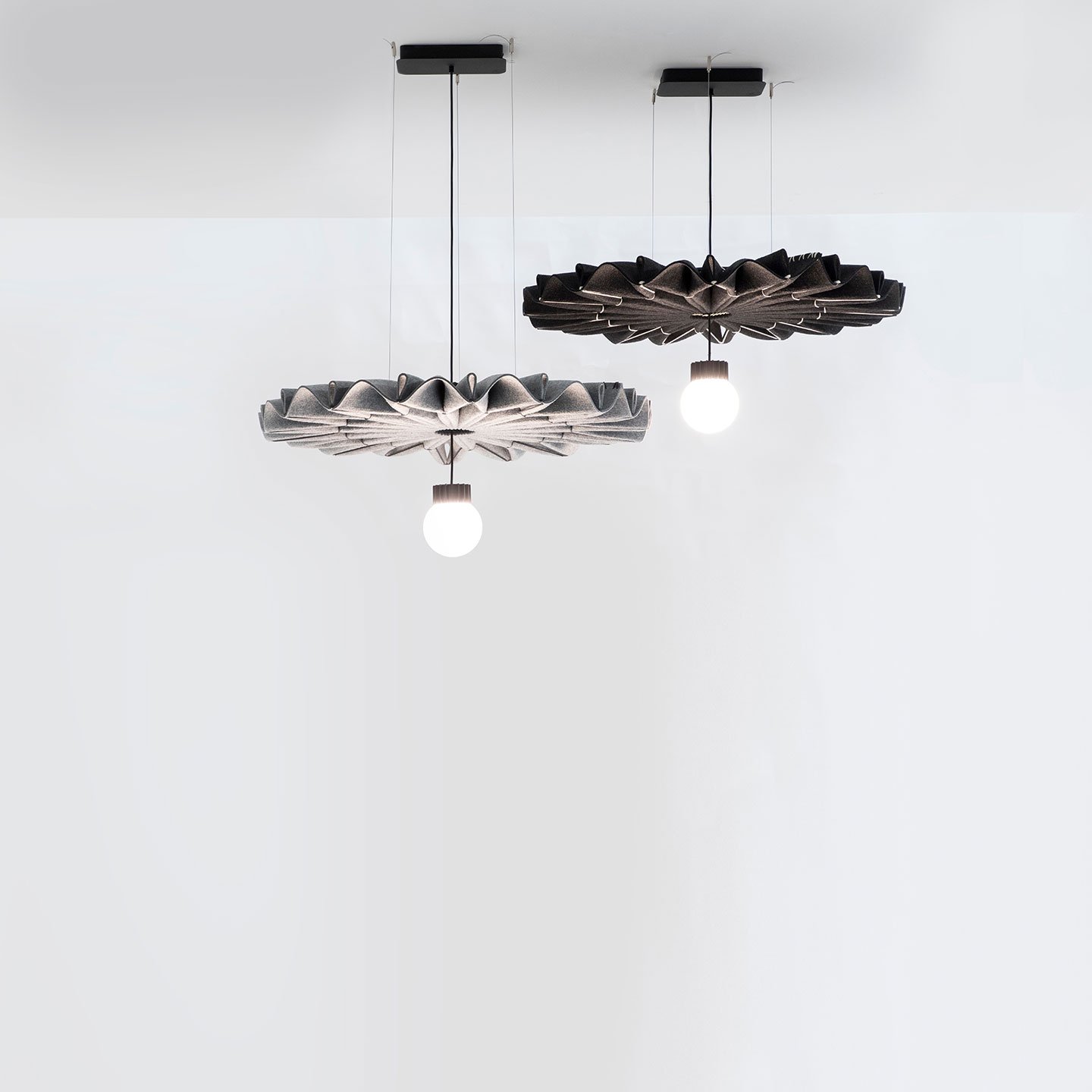 Haworth BuzziPleat LED Lighting in black and grey colors hanging from white ceiling