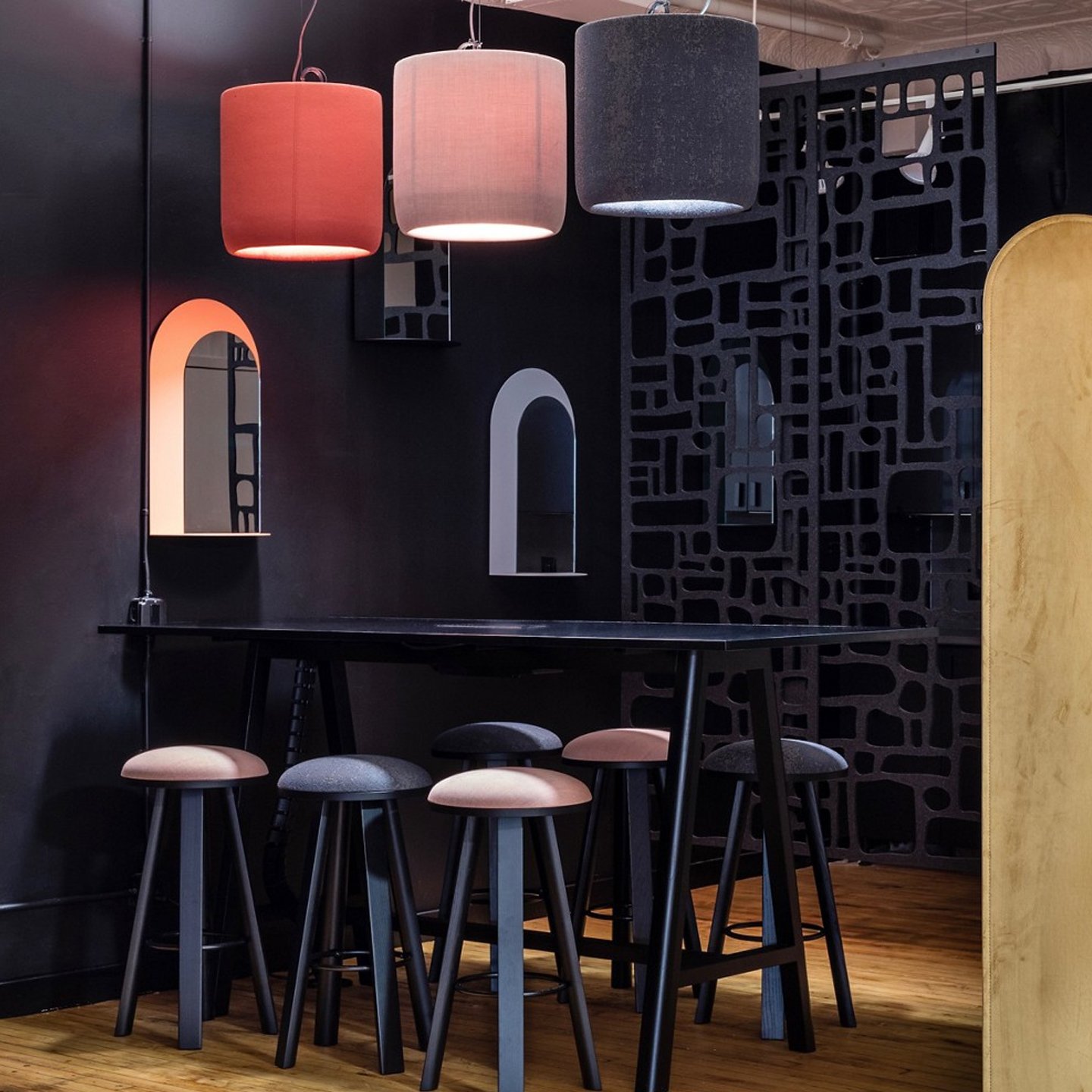 Haworth BuzziProp Lighting in red, pink and black in a dark office spae with a black table and tall chairs