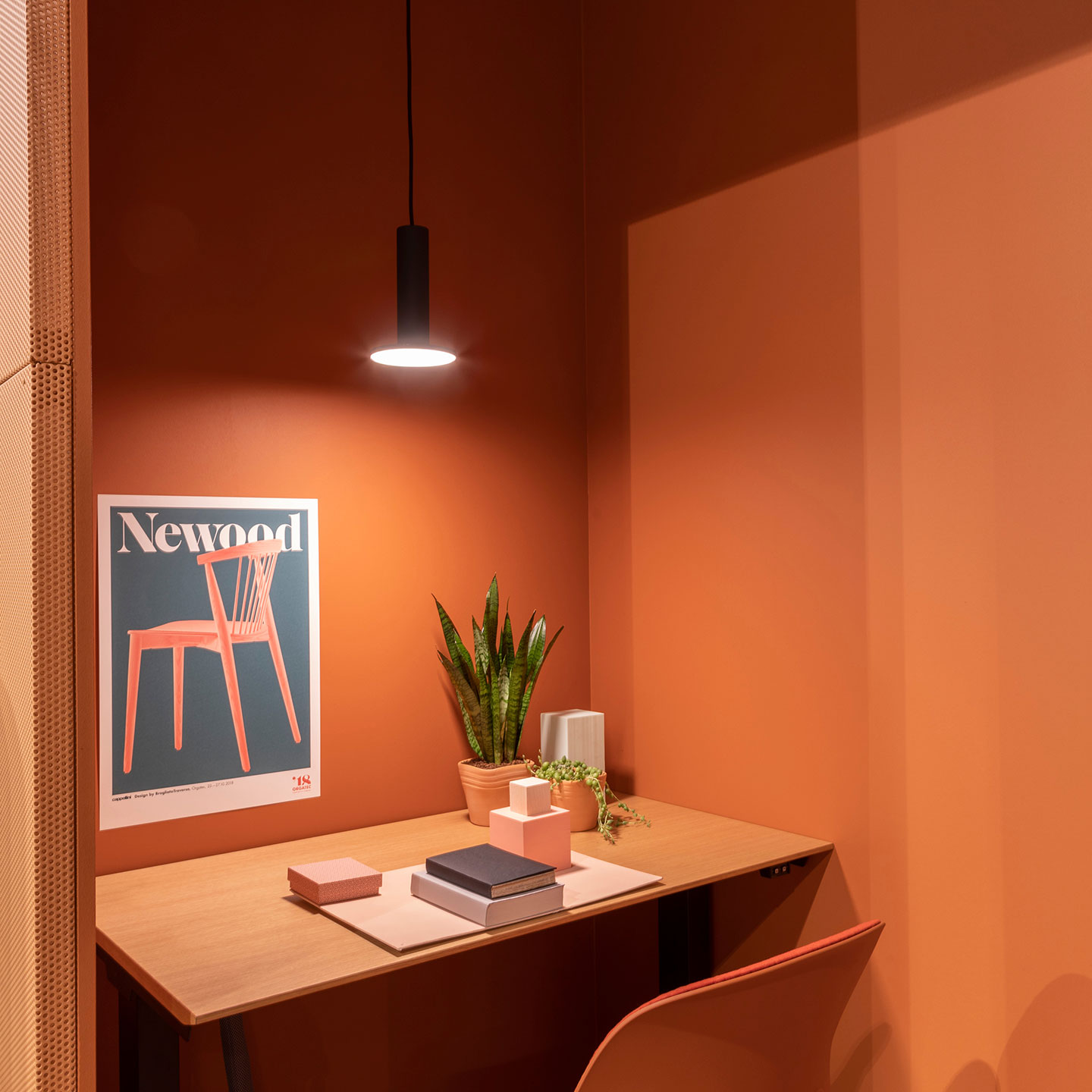 Haworth Cielo Lighting in black above a private desk space with orange walls and chairs for privacy