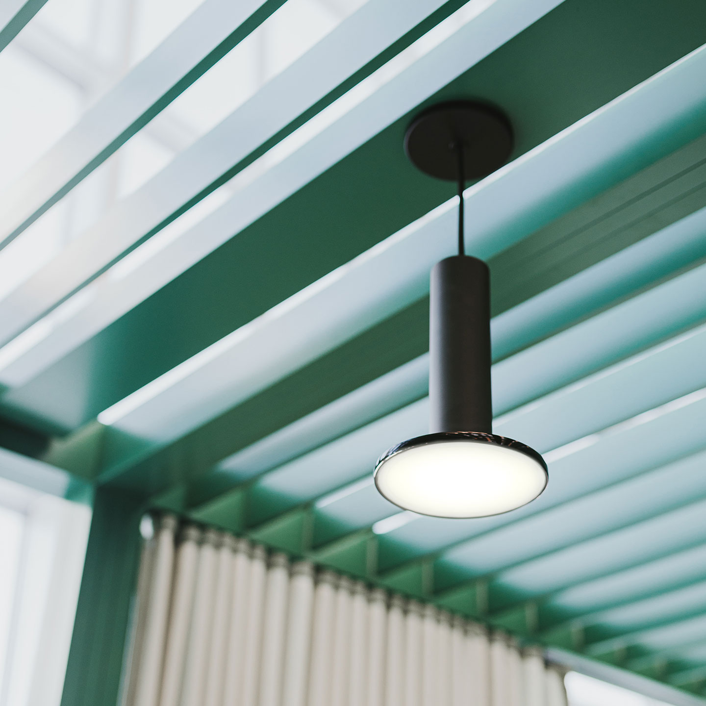 Haworth Cielo Lighting in black hanging from Pergola private workspace in green in an open office setting