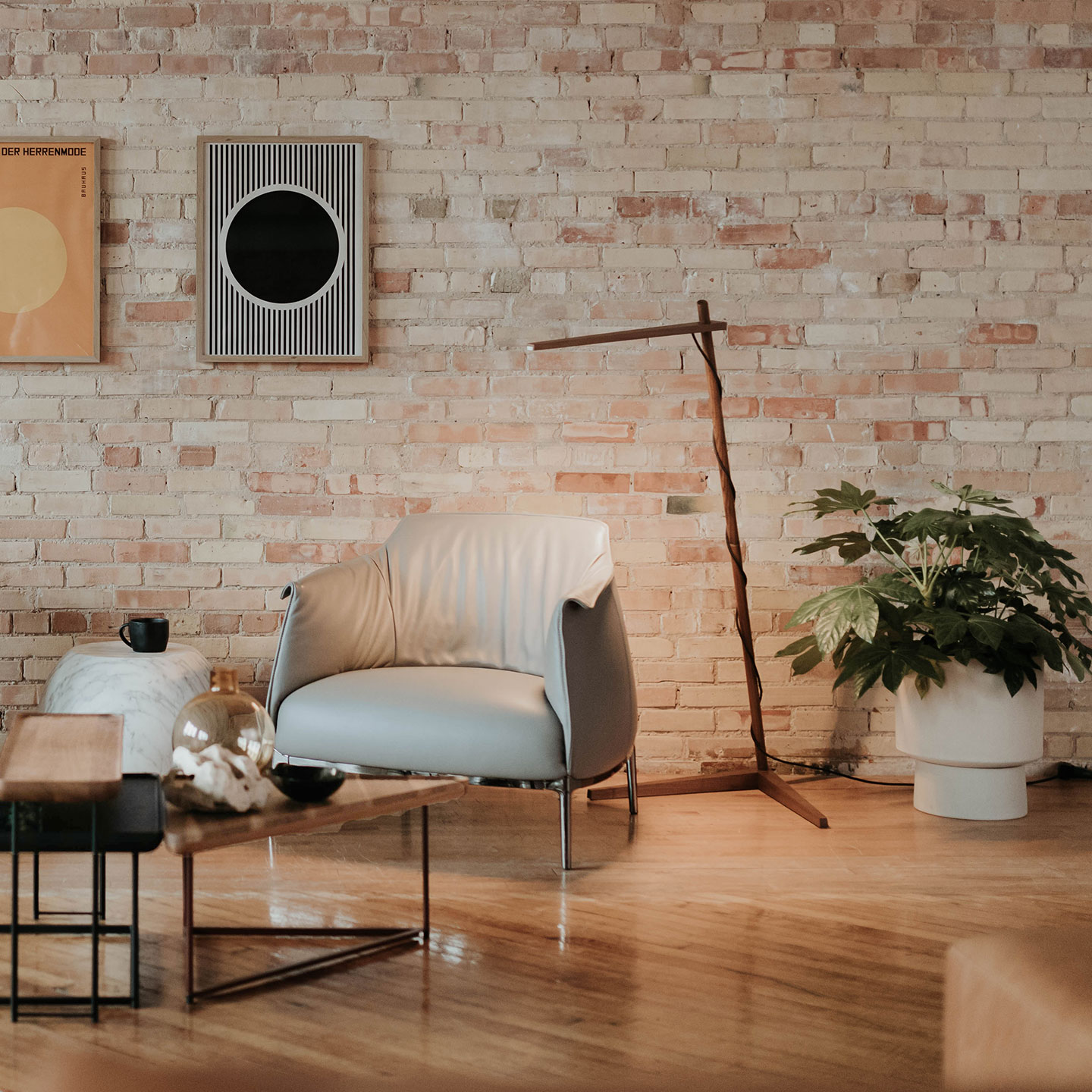 Haworth Clamp Lighting in stained wood above a chair in a lounge space with coffee table next to the chair