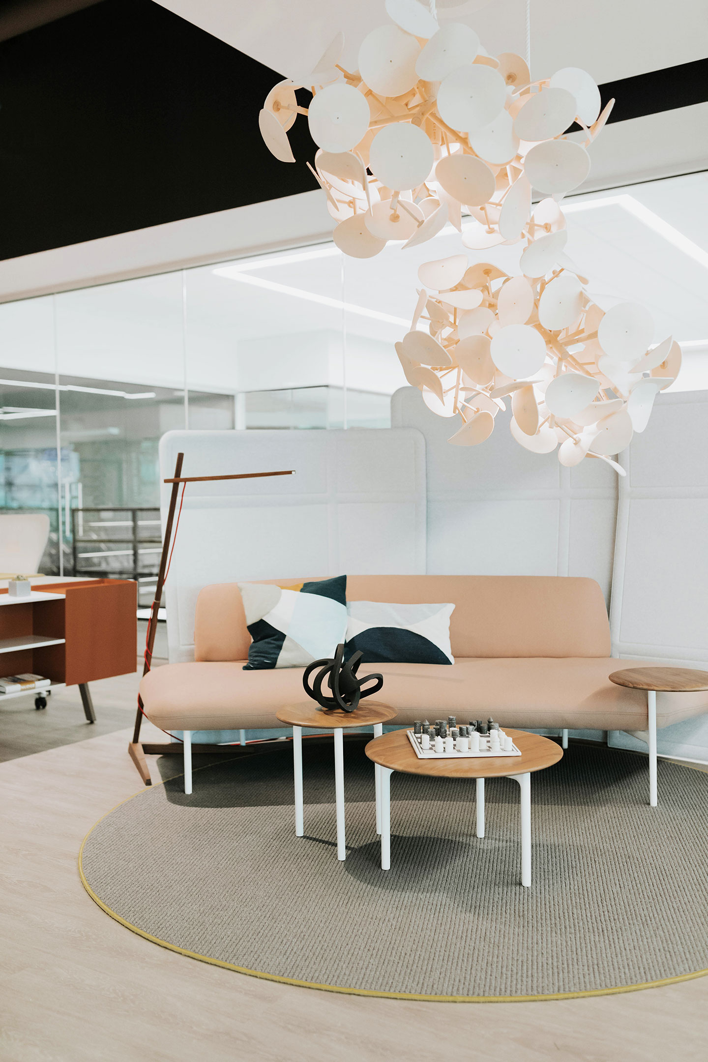 Haworth Clamp Lighting in stained wood above couch in office lounge space with coffee table 