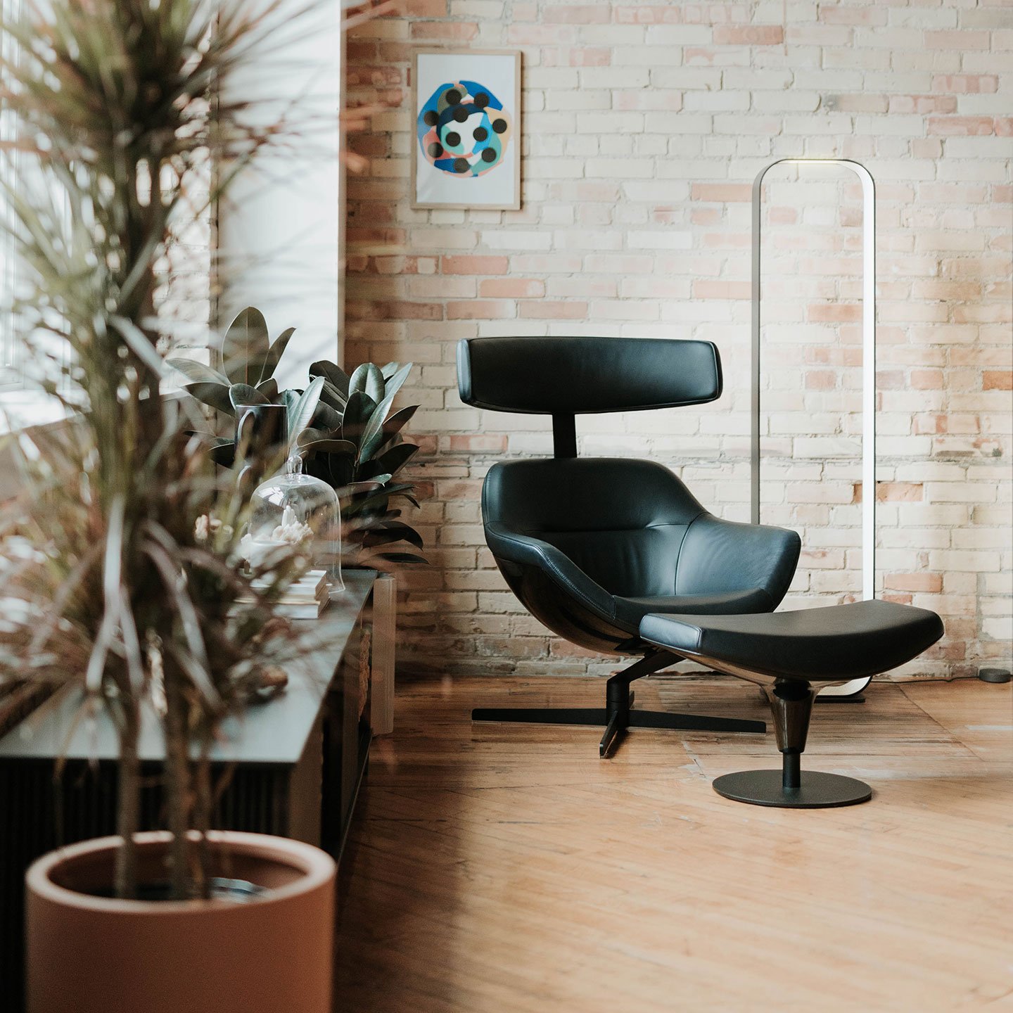 Haworth Contour Lighting in white color next to a black chair for reading in a quite lounge area