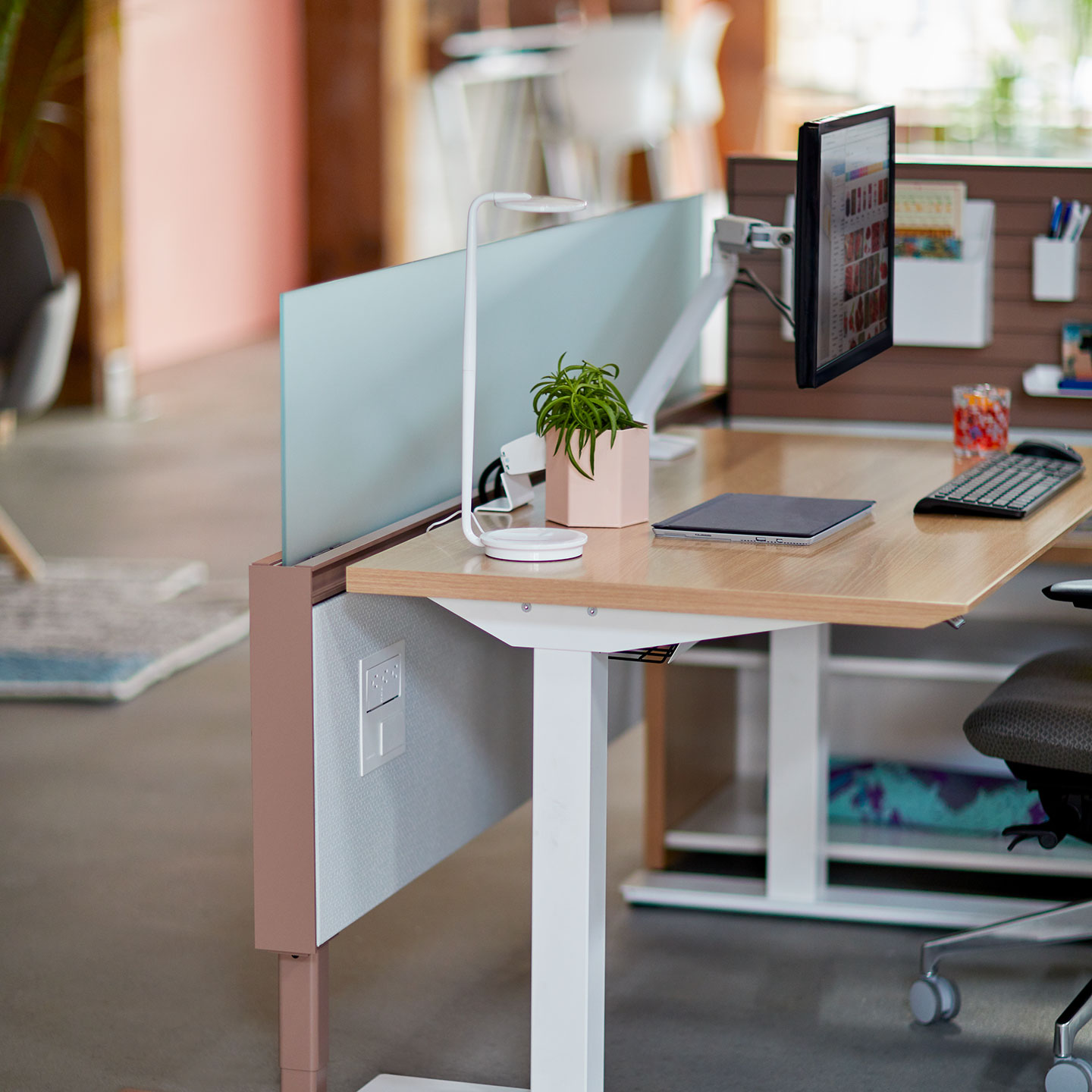 Haworth Pixo Lighting in white color on height adjustable desk with monitor and monitor arm in open office space