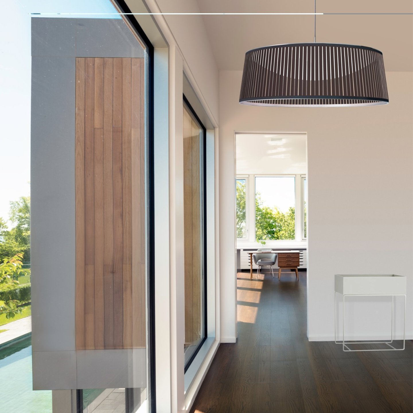 Haworth Solis Drum Lighting in black color in open home space with office and outdoor pool