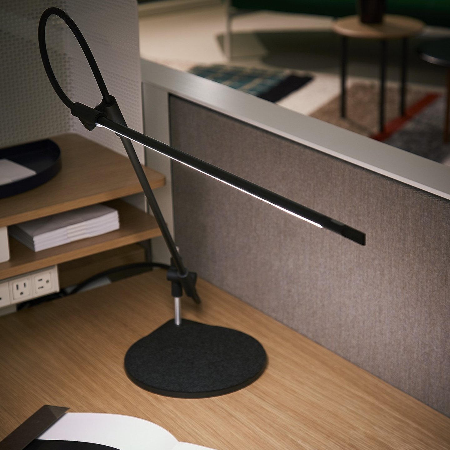 Haworth Superlight lighting in black color on wood desk with grey desk divider