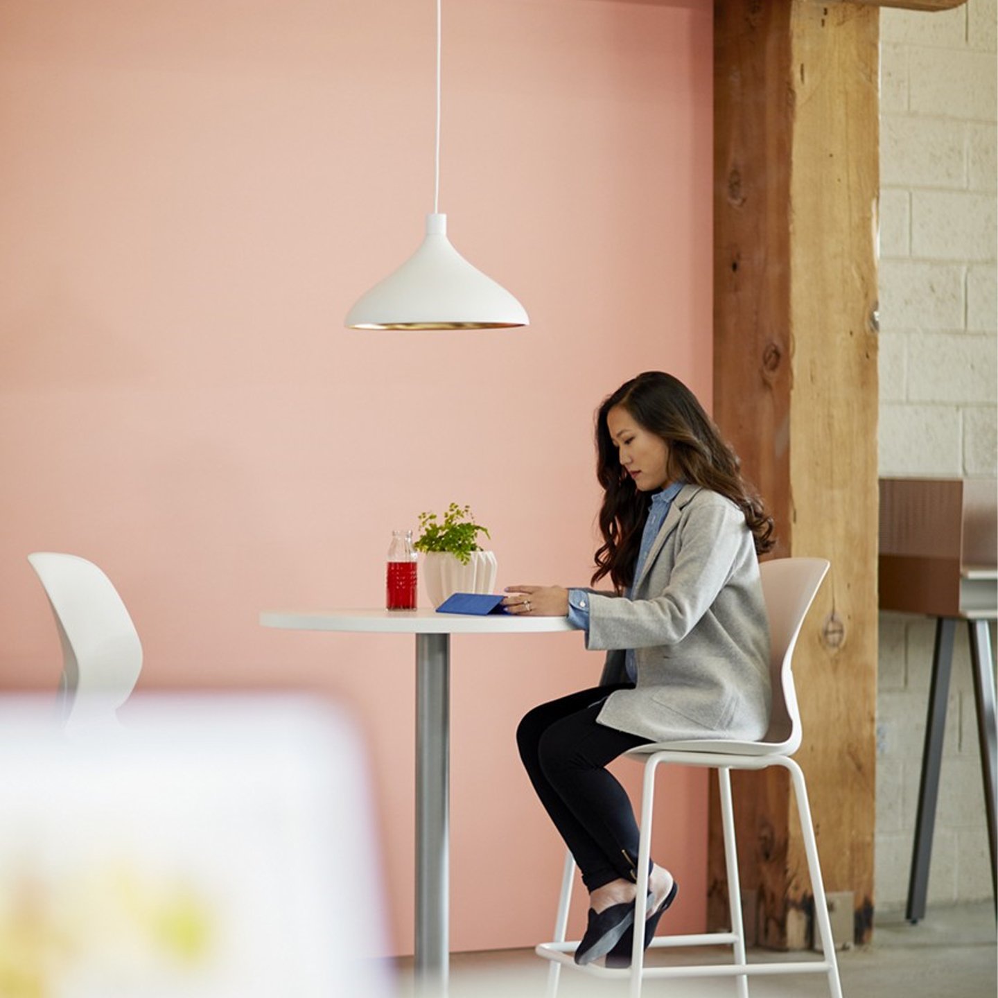 Haworth Swell Lighting in white color above office tall desk with employee working