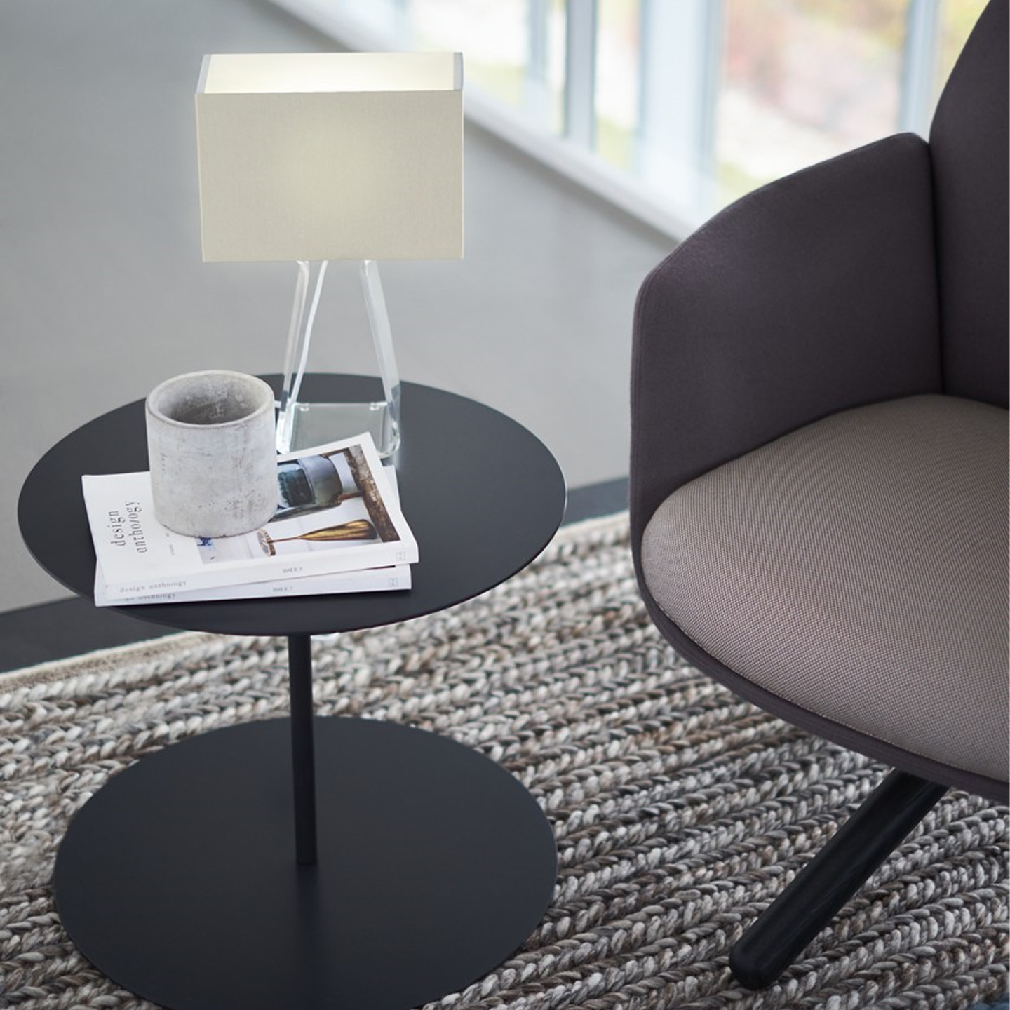 Haworth Tube Top Lighting in white on black coffee table next to black chair