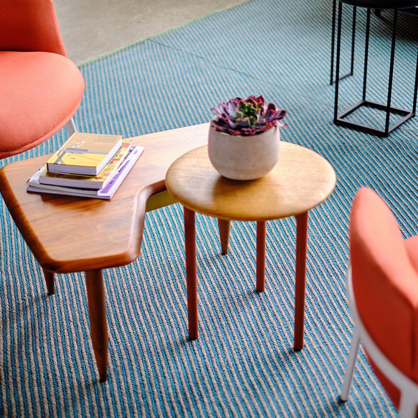 Haworth Diagonales Rug in blue and white color under a red chair and wood coffee tables