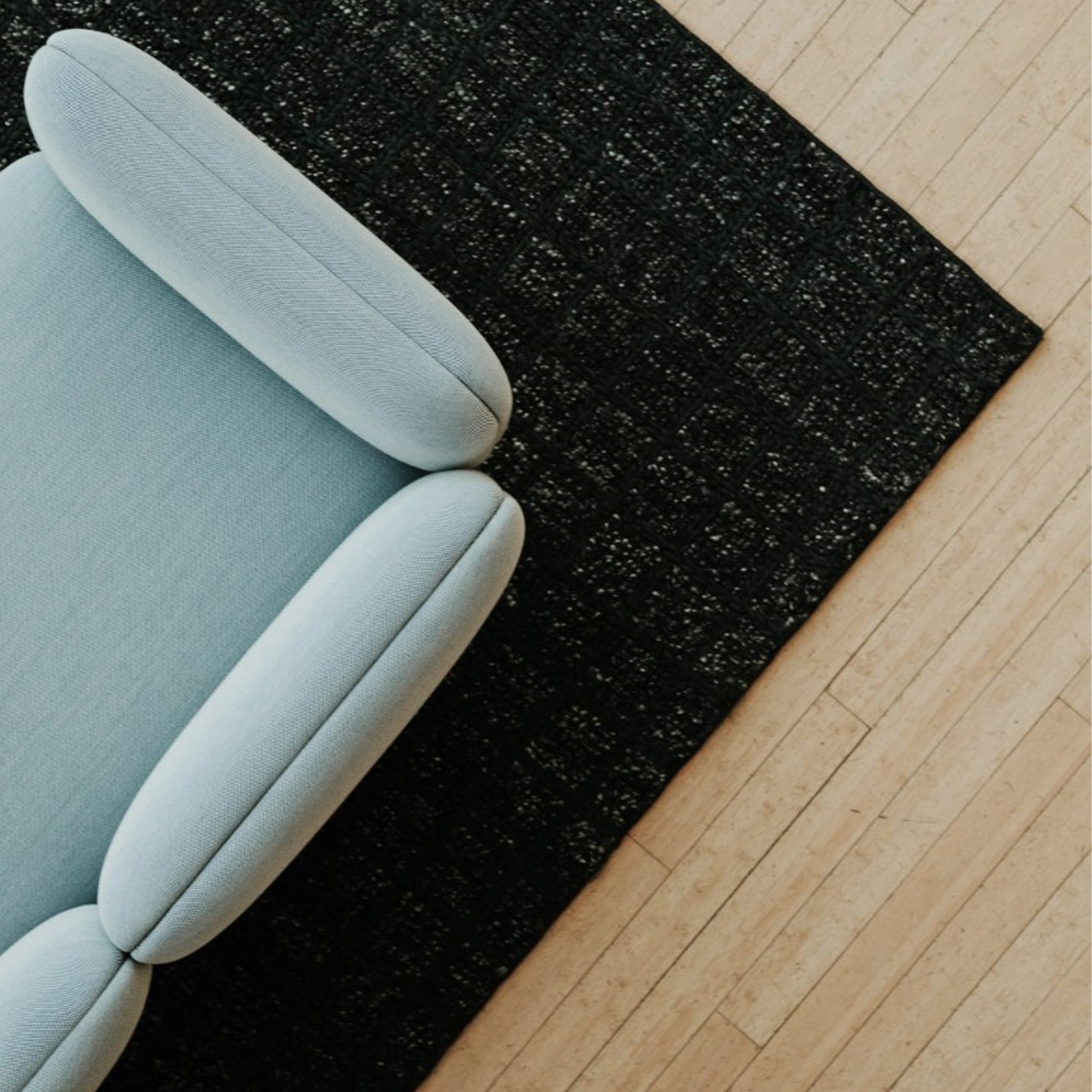 Haworth Mangas Natural Rug in black color squares pattern on floor with blue couch above it