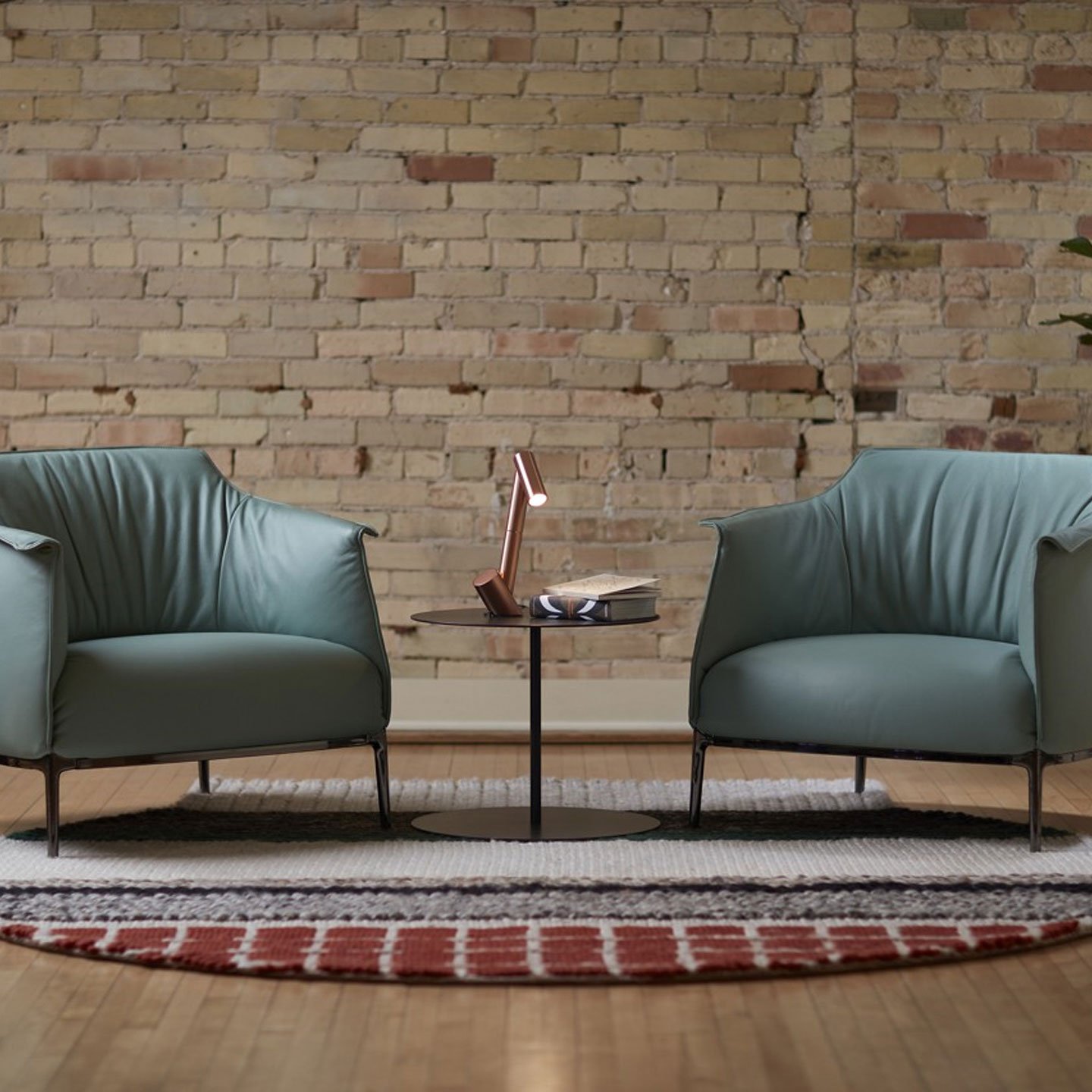 Haworth mangas Original Rug in multiple colors and circular shape under green chairs and table with light on it